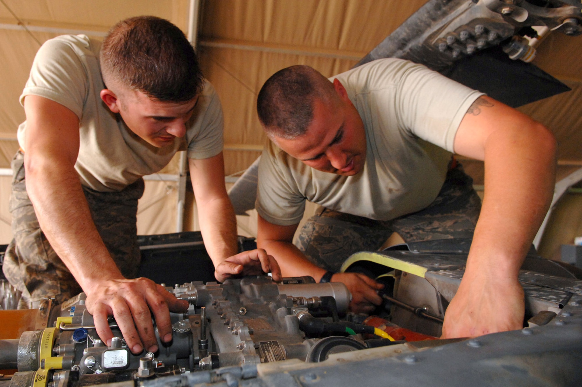 Airman 1st Class Donald Baker (left) and Staff Sgt. Tait Delzer install the left engine air intake on an HH-60 Pave Hawk helicopter March 12 at Balad Air Base, Iraq. Airman Baker and Sergeant Delzer, crew chiefs with the 64th Expeditionary Helicopter Maintenance Unit, performed an inspection on the aircraft after it had been flown 300 hours. As part of the preventative maintenance inspection, they searched carefully for cracks and corrosion. Both Airman Baker and Sergeant Delzer are deployed from Moody Air Force Base, Ga. (U.S. Air Force photo/Senior Airman Julianne Showalter)