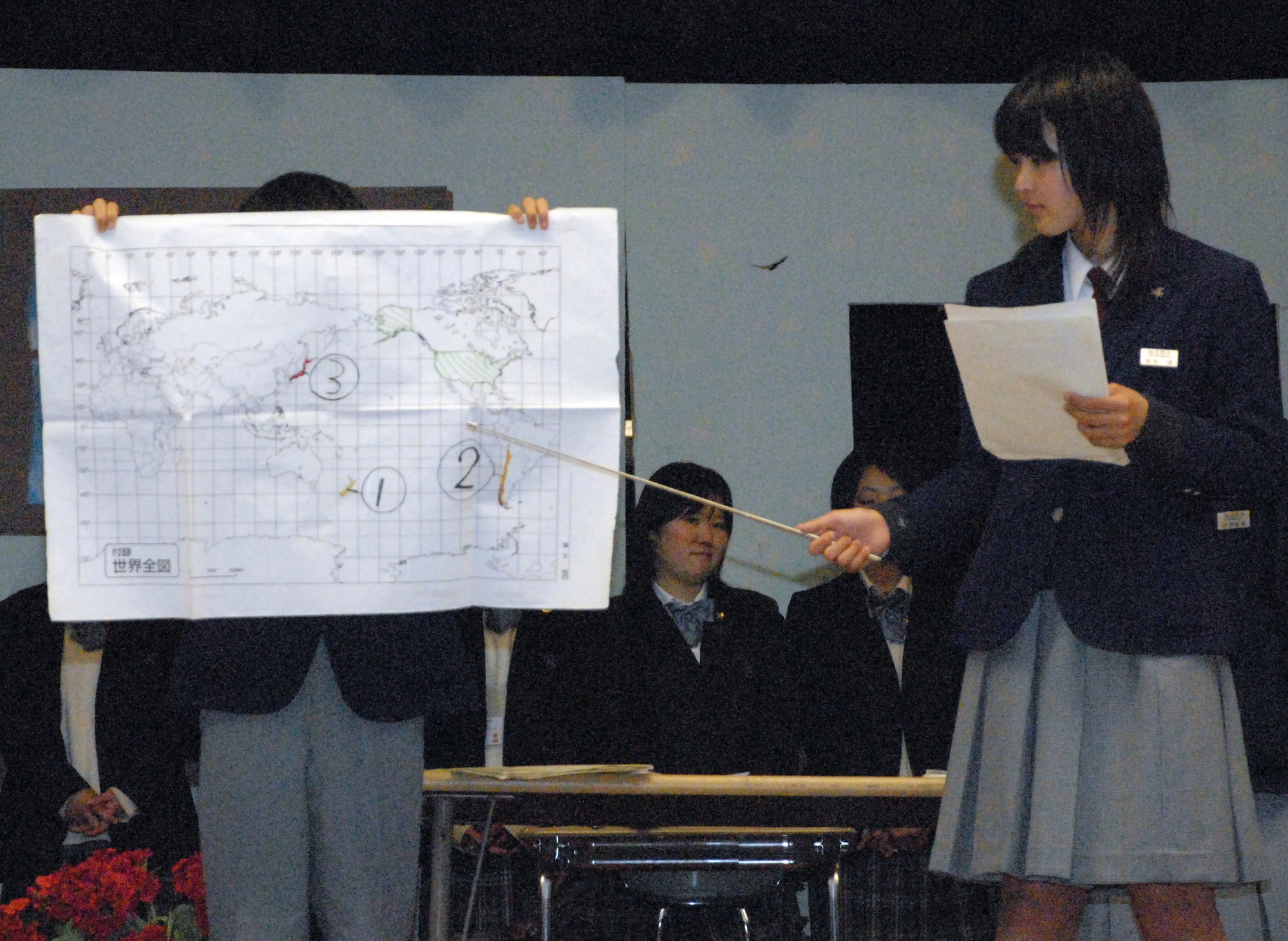 Haruka Kikuchi, a student at Iwanuma City Middle School in Japan, points to a world map during a presentation where she described the location of Japan and the Miyagi Prefecture to Dover Air Base Middle School students and parents at the DAB Middle School auditorium March 19. As part of the ninth-annual Iwanuma City and city of Dover exchange program, 20 Japanese middle and high school students and faculty members visited DAB Middle School and Dover High School recently. (U.S. Air Force photo/Tech. Sgt. Kevin Wallace)