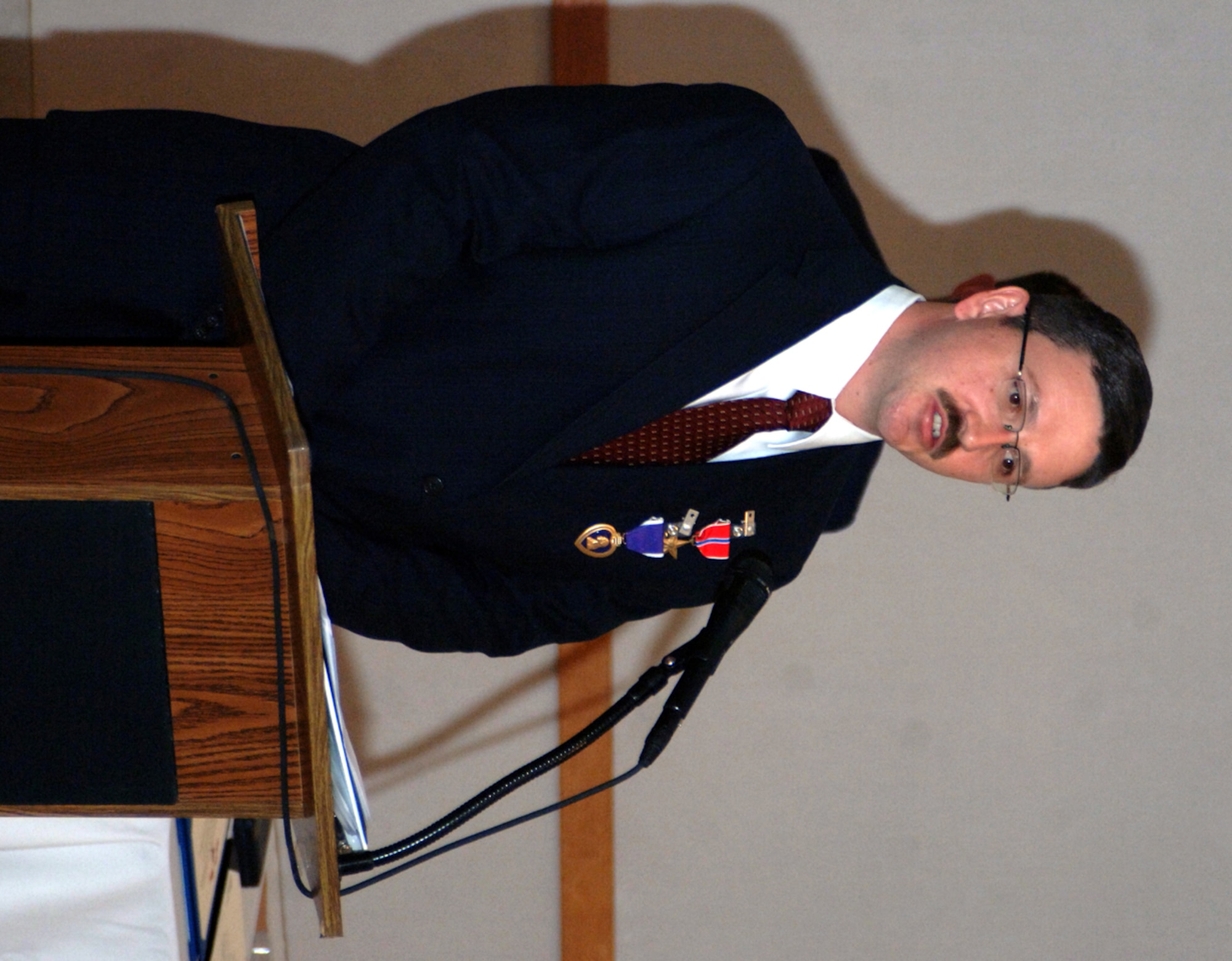 OSI Special Agent Jac Christiansen speaks at his award ceremony after receiving a Bronze Star, a Purple Heart and a Combat Action Medal for his services during his 2007 deployment in support of Operation Iraqi Freedom. 