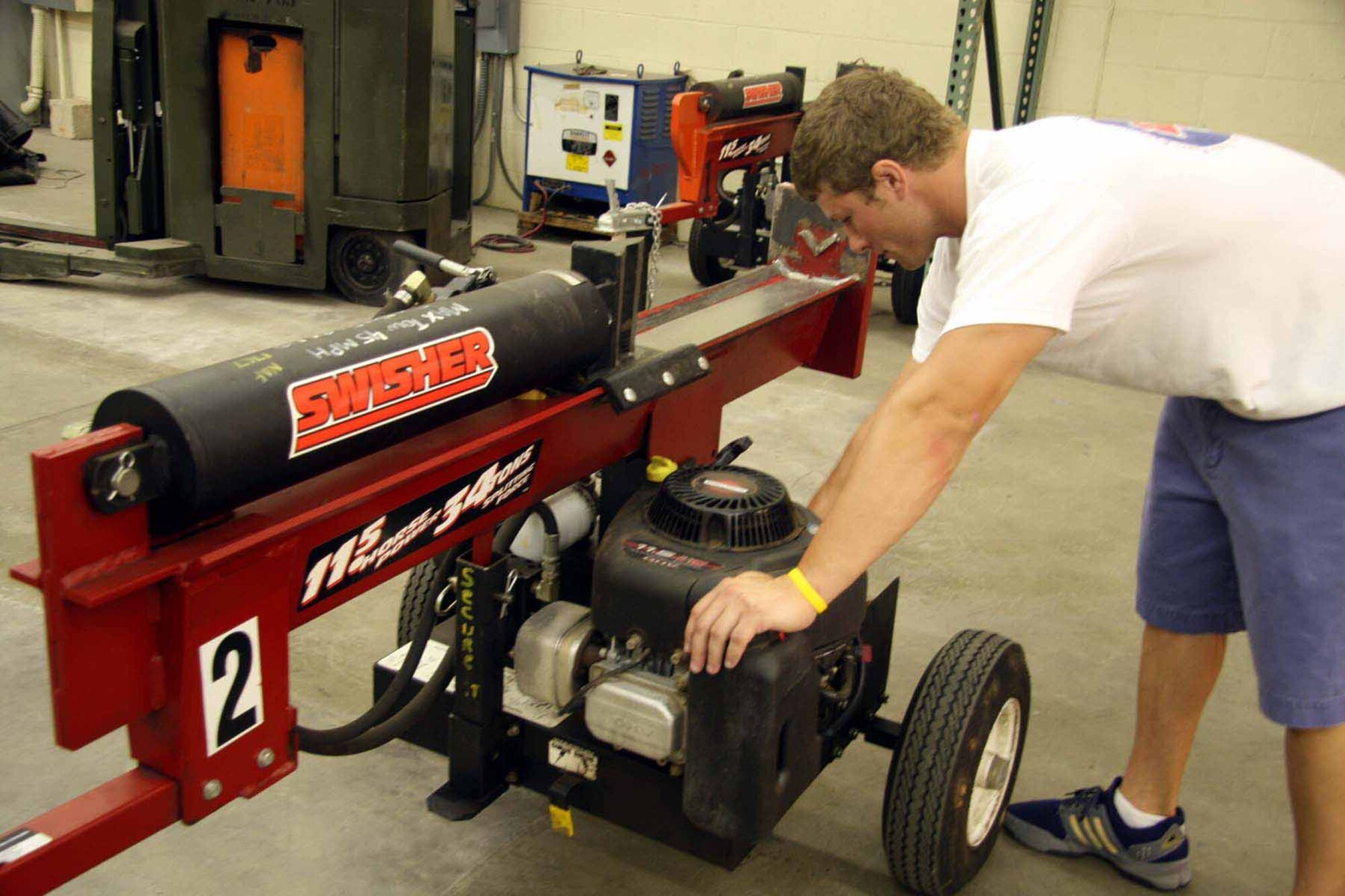 Anthony Rodriques looks over a log splitter before sending it out with a customer.  (Air Force photo by Becky Pilifant)