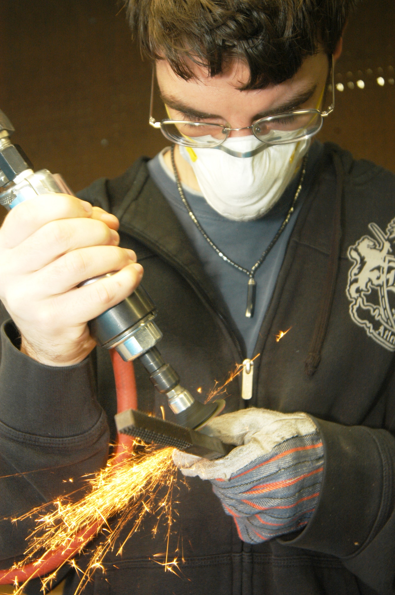 Josh Hall, a consumer at Happy Hour, uses a dremel tool to de-number a tool so it can be reused. U. S. Air Force photo by Sue Sapp  