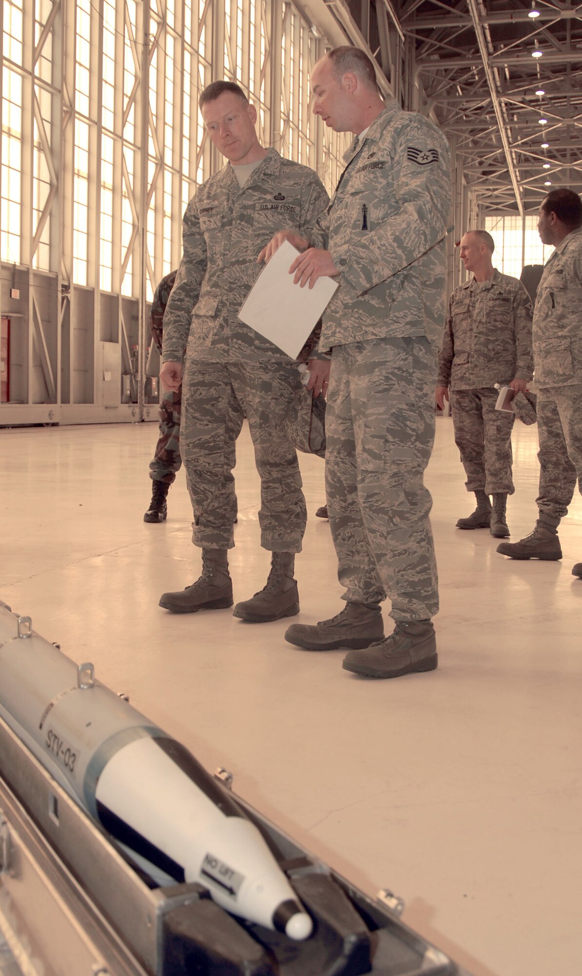 Staff Sgt. Jason Buffell, 412th Maintenance Group aircraft armament specialist, shows Chief Master Sgt. William Gurney, Air Force Materiel Command command chief, a weapons display during the command chief's visit to Edwards on March 17 and 18. Chief Gurney visited many of Edwards maintenance shops as well as participated in a fitness run and met with Airmen attending the local Airmen's Leadership School.  (Air Force photo by Senior Airman Julius Delos Reyes)