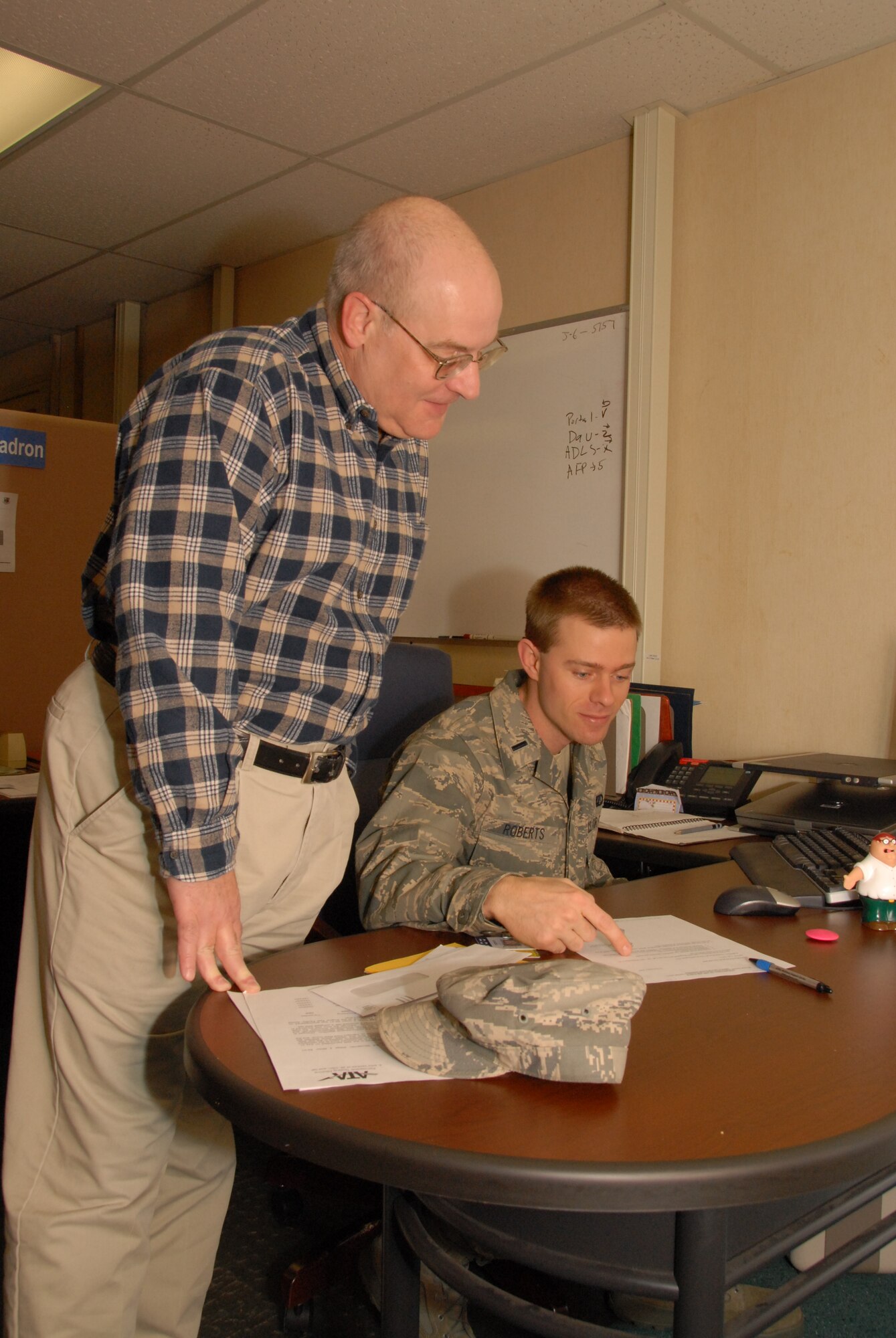 Randall Quinn, aerospace engineer for the lead rocket propulsion test mission area, looks over the shoulder of Test Project Manager 1st Lt. Patrick Roberts. Lieutenant Roberts manages Minuteman test projects by working cost and scheduling through Arnold Engineering Development Center  (AEDC) management and Hill Air Force Base. Ironically, both men are from the Missouri. Quinn has been at AEDC since 1975 and Lieutenant Roberts has been here since 2004. (Photo by David Housch)