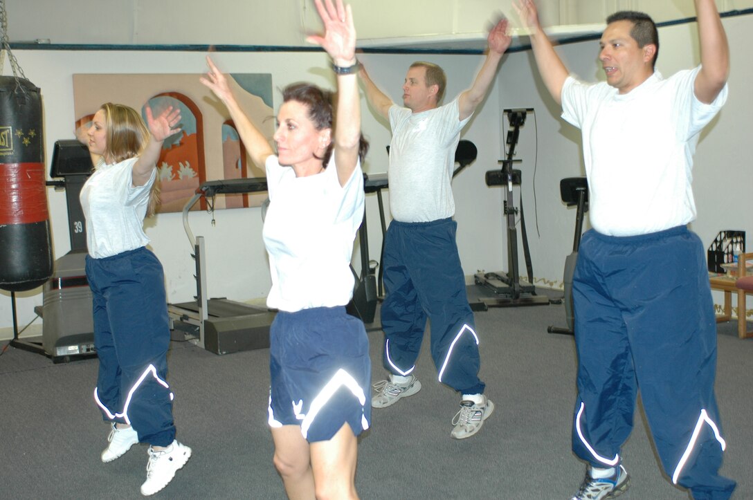 Members of the first 9G Force Fitness class continue to apply what they learned weeks after the rigorous program ended. (From left to right) Staff Sgt. Kathleen Branch, Tech. Sgt. Mary Thompson, Tech. Sgt. Mike Coleman and Staff Sgt. Jose Toro warm up with jumping jacks. (Photo by Capt. Gabe Johnson)