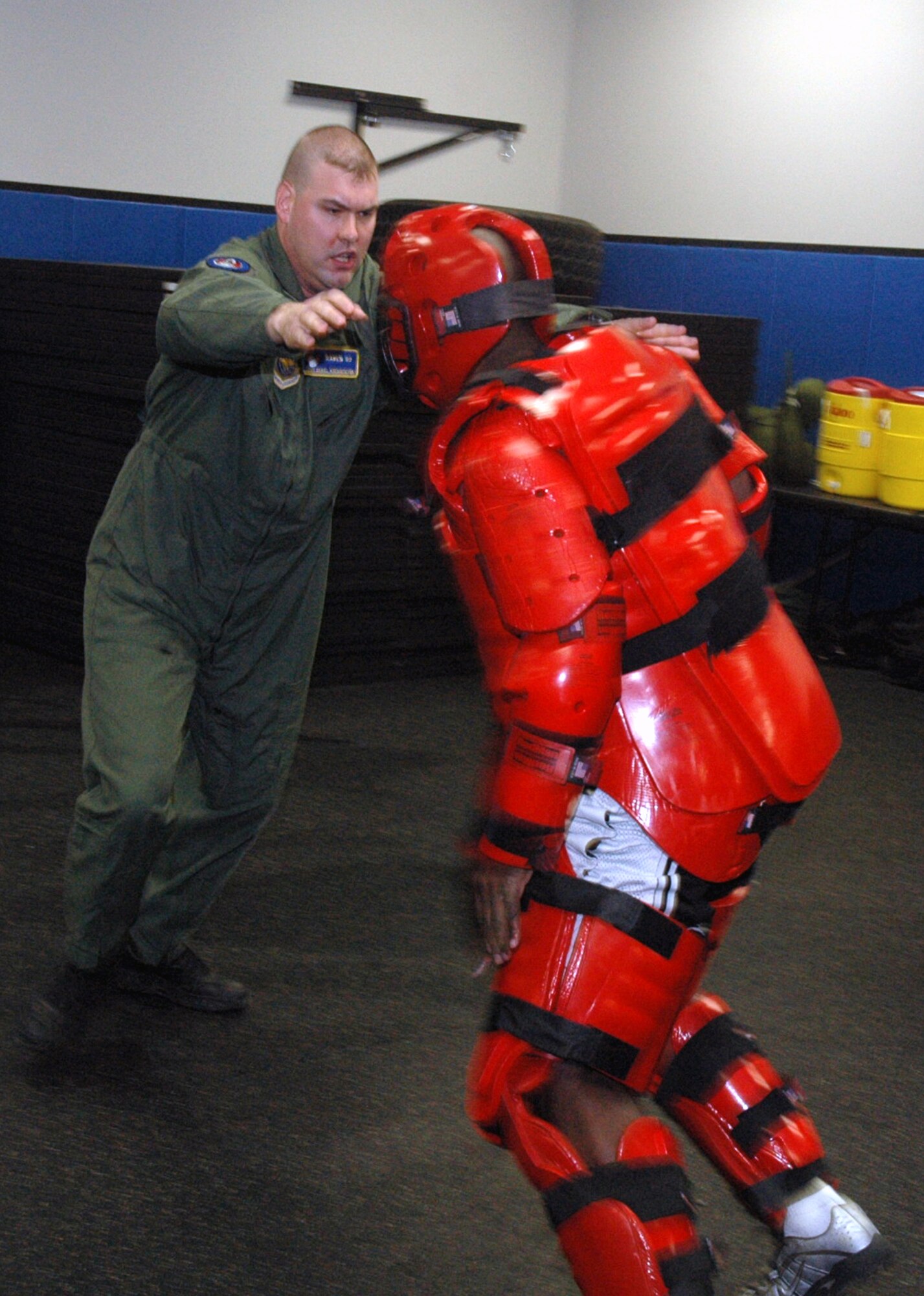Tech. Sgt. Jeffrey Cadogan (in red man suit), Raven instructor with the U.S. Air Force Expeditionary Center's 421st Combat Training Squadron, and Tech. Sgt. Daniel Koenigsmann, also a Raven instructor, hold a Raven demonstration March 19, 2008, in the Center on Fort Dix, N.J.  In this stage of the demonstration, Sergeant Koenigsmann is using self defense to respond to an "aggressor." Phoenix Raven is a specialized course for security personnel teaching subjects such as internal and external aircraft security, self defense and weapons handling. (U.S. Air Force Photo/Tech. Sgt. Scott T. Sturkol) 