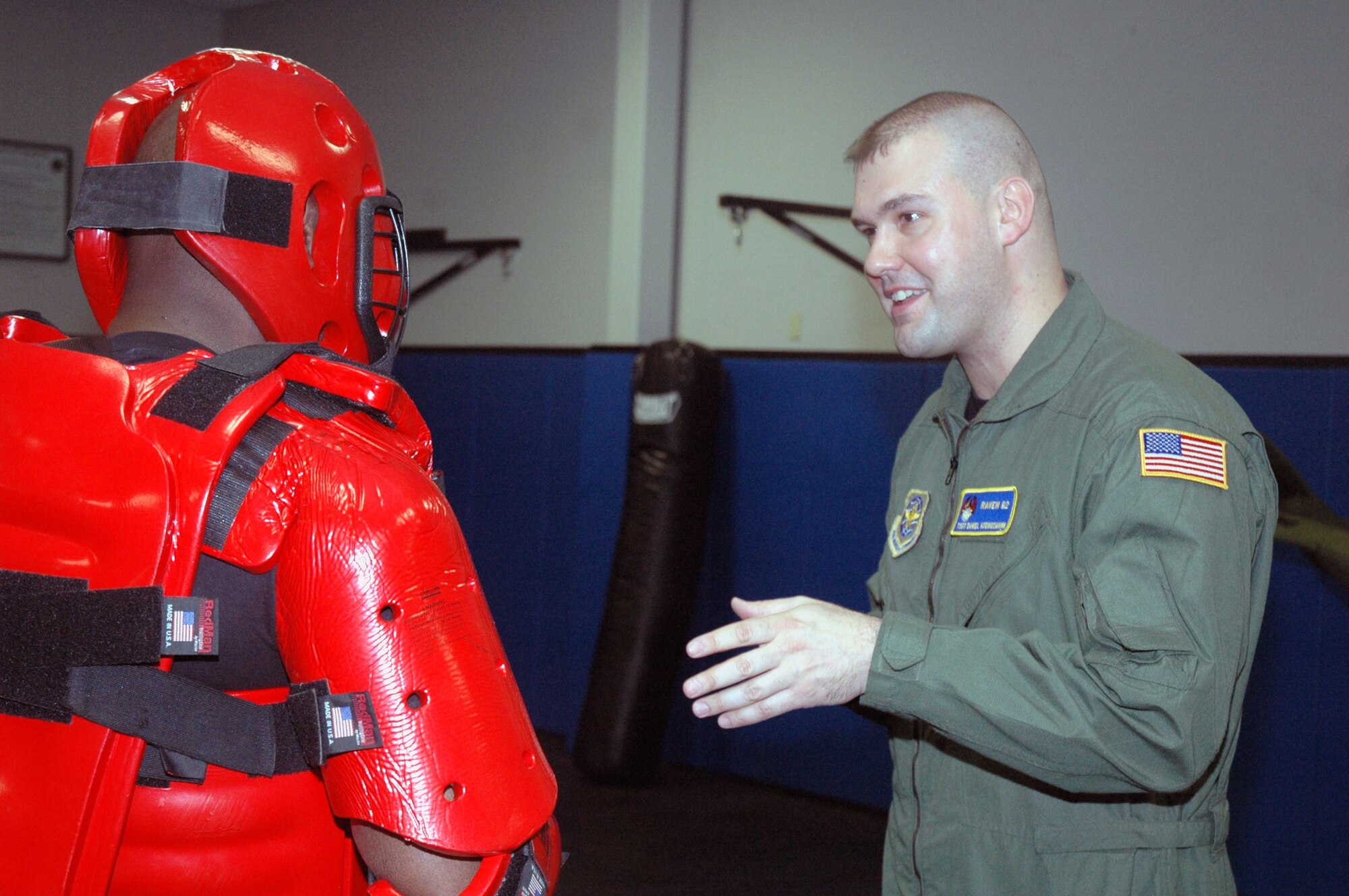 Tech. Sgt. Jeffrey Cadogan (in red man suit), Raven instructor with the U.S. Air Force Expeditionary Center's 421st Combat Training Squadron, and Tech. Sgt. Daniel Koenigsmann, also a Raven instructor, hold a Raven demonstration March 19, 2008, in the Center on Fort Dix, N.J.  In this stage of the demonstration, Sergeant Koenigsmann is using verbal judo to calm the "aggressor." Phoenix Raven is a specialized course for security personnel teaching subjects such as internal and external aircraft security, self defense and weapons handling. (U.S. Air Force Photo/Tech. Sgt. Scott T. Sturkol) 