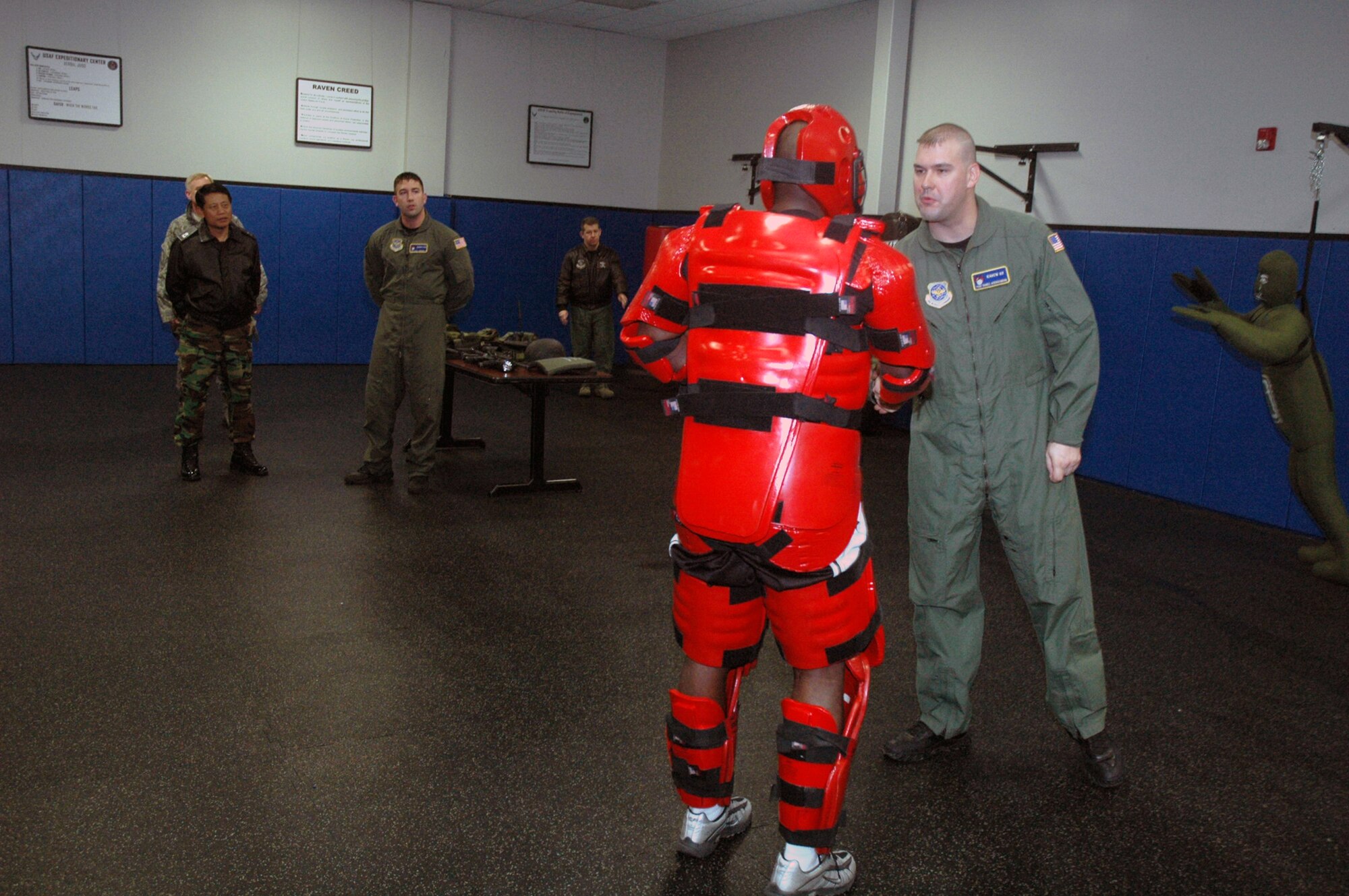 Tech. Sgt. Jeffrey Cadogan (in red man suit), Raven instructor with the U.S. Air Force Expeditionary Center's 421st Combat Training Squadron, and Tech. Sgt. Daniel Koenigsmann, also a Raven instructor, hold a Raven demonstration for Republic of Korea Brig. Gen. Young-Ki Eun, Director of Civil Engineer Division, ROK air force headquarters, March 19, 2008, in the Center on Fort Dix, N.J.  The demonstration was part of General Eun's official visit to the Center.  (U.S. Air Force Photo/Tech. Sgt. Scott T. Sturkol) 