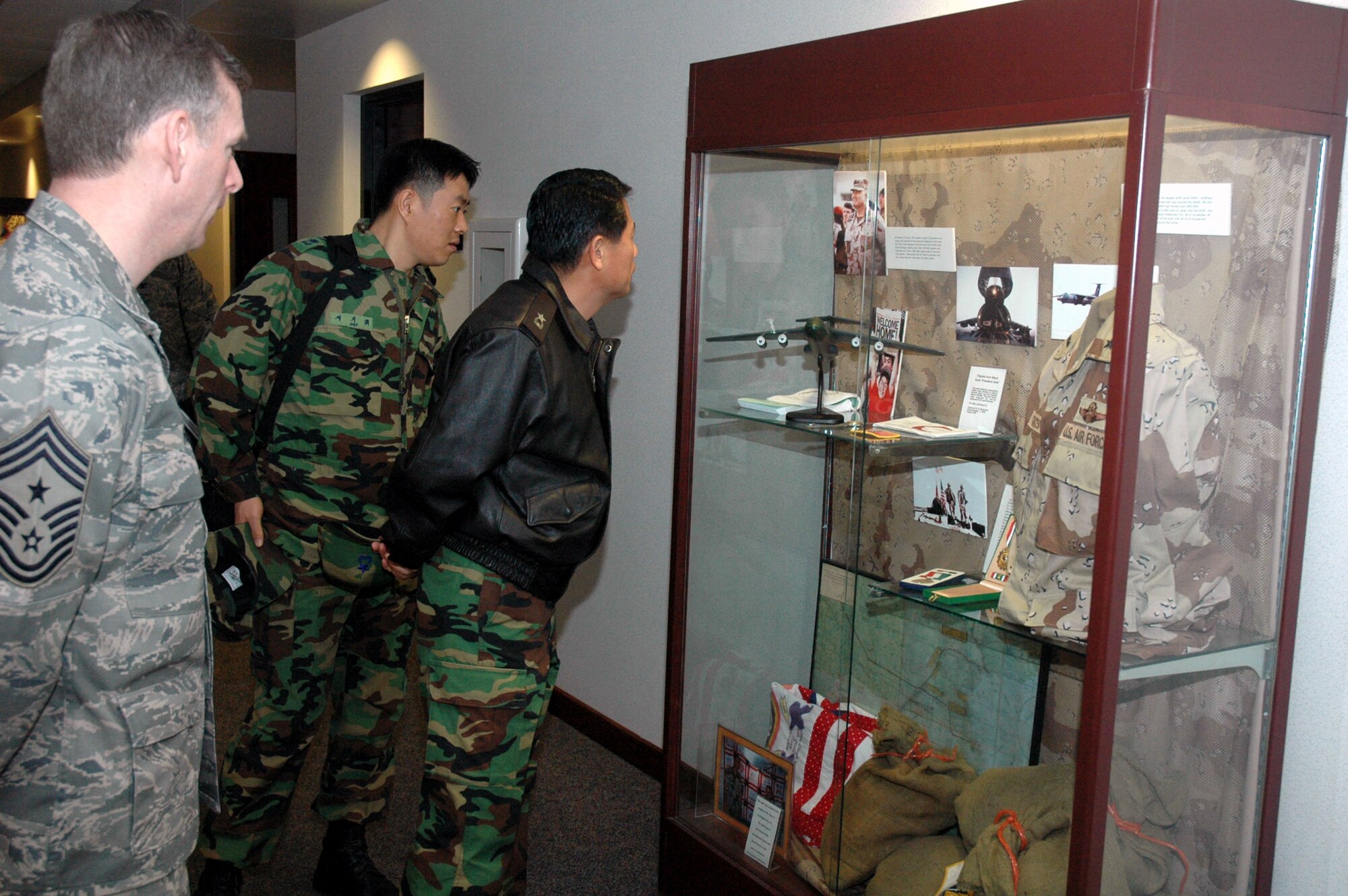 Chief Master Sgt. Jeffry Helm, U.S. Air Force Expeditionary center command chief, shows Republic of Korea Brig. Gen. Young-Ki Eun, Director, Civil Engineer Division, ROK Air Force Headquarters, and Maj. Gihwi Seo, also from the ROK air force, the Operation Desert Storm display case in the Center during General Eun's official visit March 19, 2008, on Fort Dix, N.J.  General Eun visited to learn more about the Center and the Center's operations for Air Force Exercise Eagle Flag.  (U.S. Air Force Photo/Tech. Sgt. Scott T. Sturkol) 