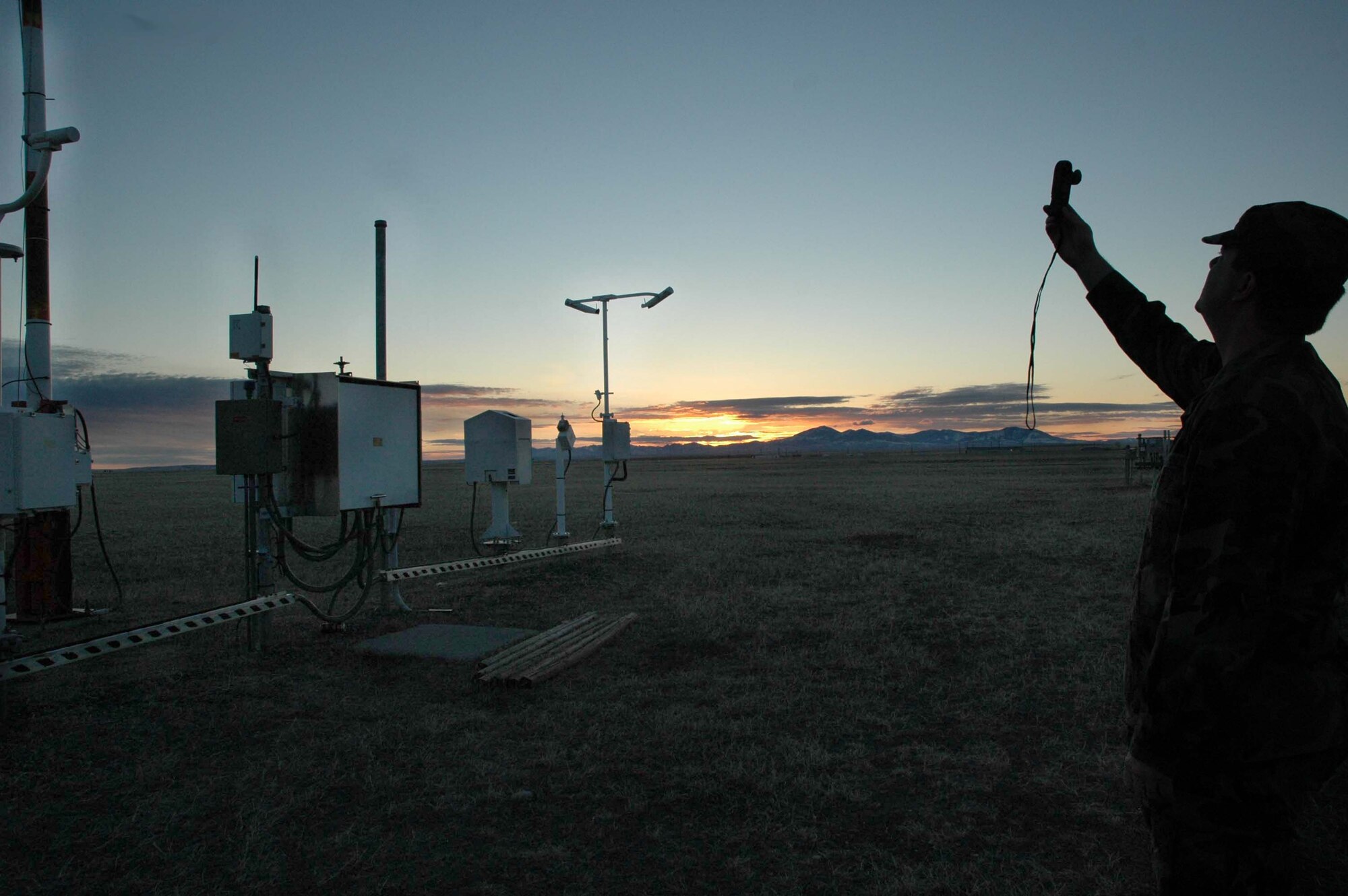 Capt. Daniel MacKeen, 341st Operations Support Squadron weather flight commander, goes out to the automated surface observation site as the sun rises to make sure the equipment is running smoothly and properly. The ASOS is located across the flightline. (U.S. Air Force photo/Airman 1st Class Emerald Ralston)