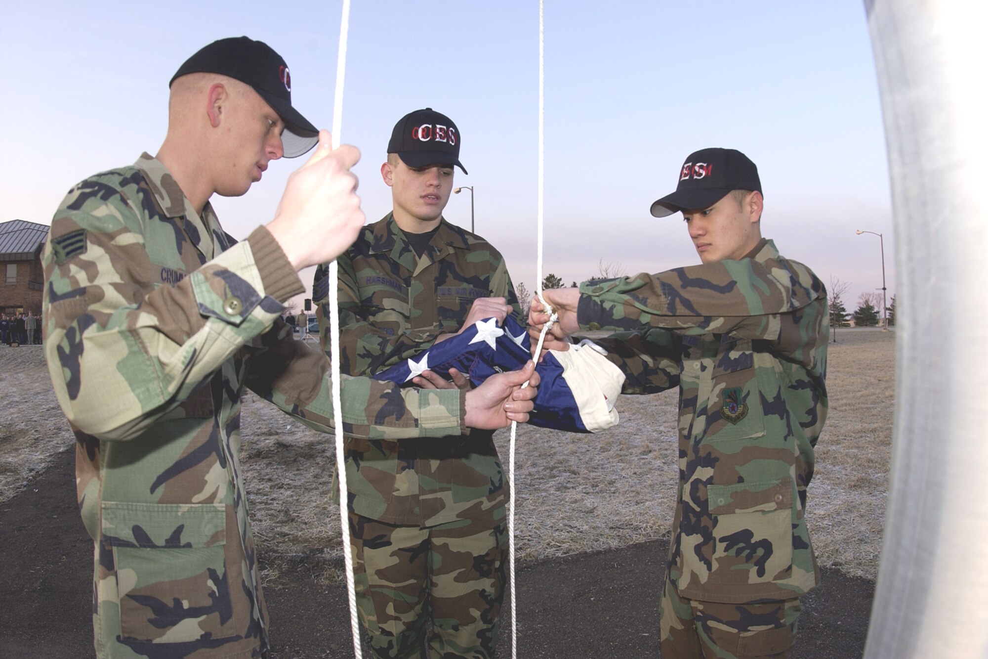 GRISSOM AIR RESERVE BASE, Ind., -- Grissom Civil Engineers, from left, Senior Airman Matthew Crummel, Staff Sgt. Daniel Harshman, and Senior Airman Andrew Htaik, prepare to raise the flag on the new base flag pole for the first time. Grissom's new base flag pole is located near the intersection of Grissom Avenue and Boxcar Street. (U.S. Air Force photo/Tech. Sgt. Doug Hays)