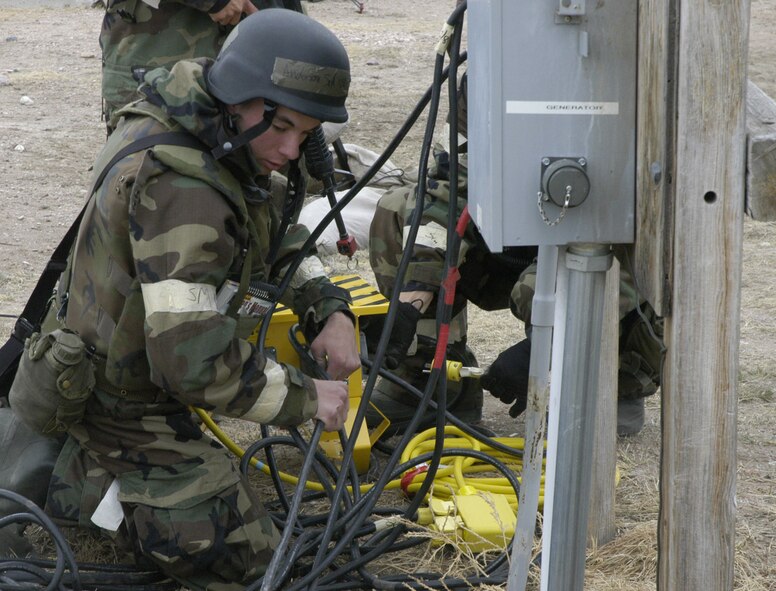 Senior Airman Mark Anderson, 90th CES, connects lighting and power circuits for the tents at the base training field March 13 in mission oriented protective posture  2. The Airmen were in MOPP 2 throughout the exercise, donning MOPP 4 for missile and chemical attacks (U.S. Air Force photo/2nd Lt. Lisa Meiman).