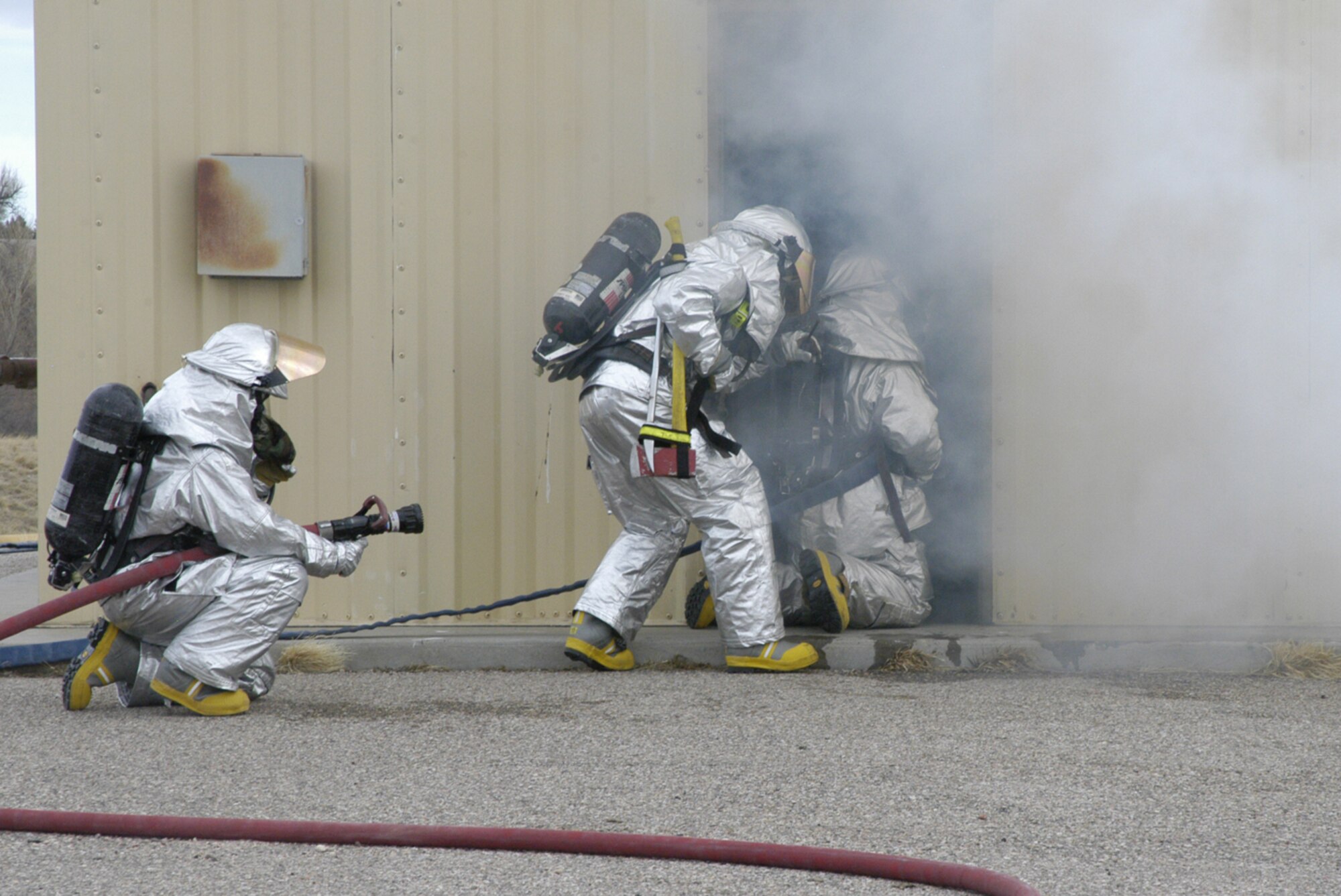 Firefighters from Warren’s fire department respond to a controlled fire in a building at the base training field March 13. Extinguishing the fire and rescuing two mannequins was part of a training exercise (U.S. Air Force photo by 2nd Lt. Lisa Meiman).