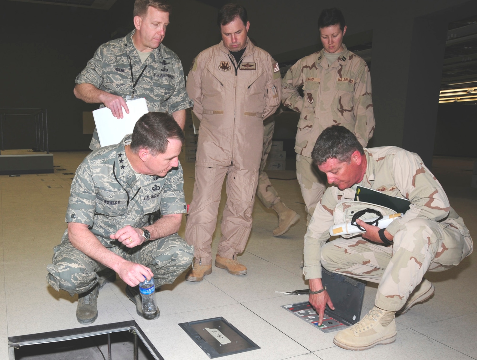 Electronic Systems Center Commander Lt. Gen. Ted F. Bowlds (clockwise from left), 350th Electronic Systems Wing Commander Brig. Gen. Pete Hoene, and members of the Combined Air and Space Operations Center Program Management Office Col. Mark Bronakowski, Capt. Amber Ward and Hal Steinman examine the floor boxes in the CAOC's new facility during General Bowlds' March 4 site visit.  The floor boxes will be the main source of power for the COAC's workstations and phone lines once the summer installation takes place in July.  (Photo by Staff Sgt. Joshua Peargin)

