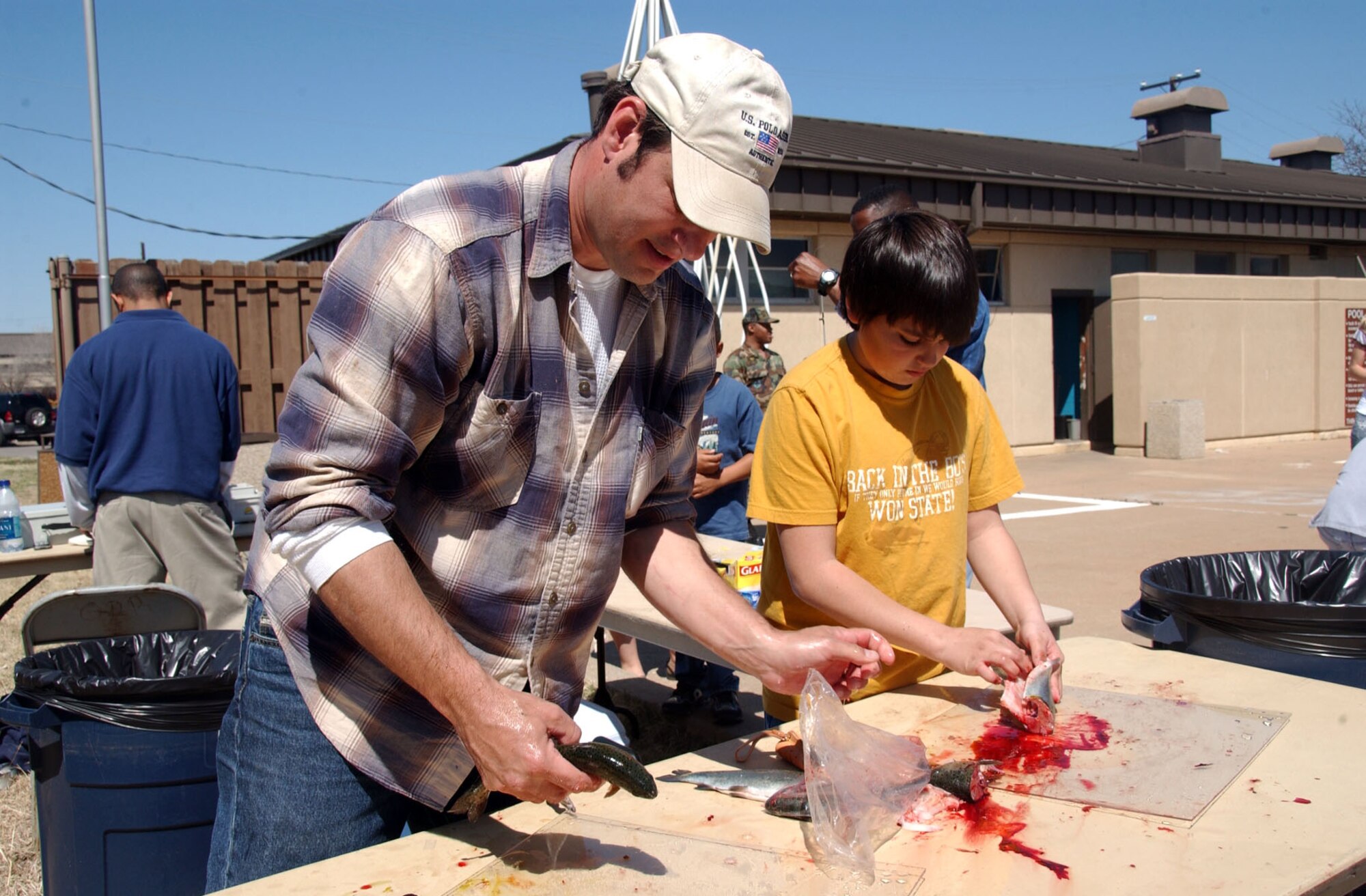 ALTUS AIR FORCE BASE, Okla. -- Tim Case and his son, Josh, 12, fillet fish for the participants during the opening day of the 14th Annual Outdoor Recreation Trout Derby at the Base Pool March 20. (U.S. Air Force photo by Senior Airman Clinton Atkins)