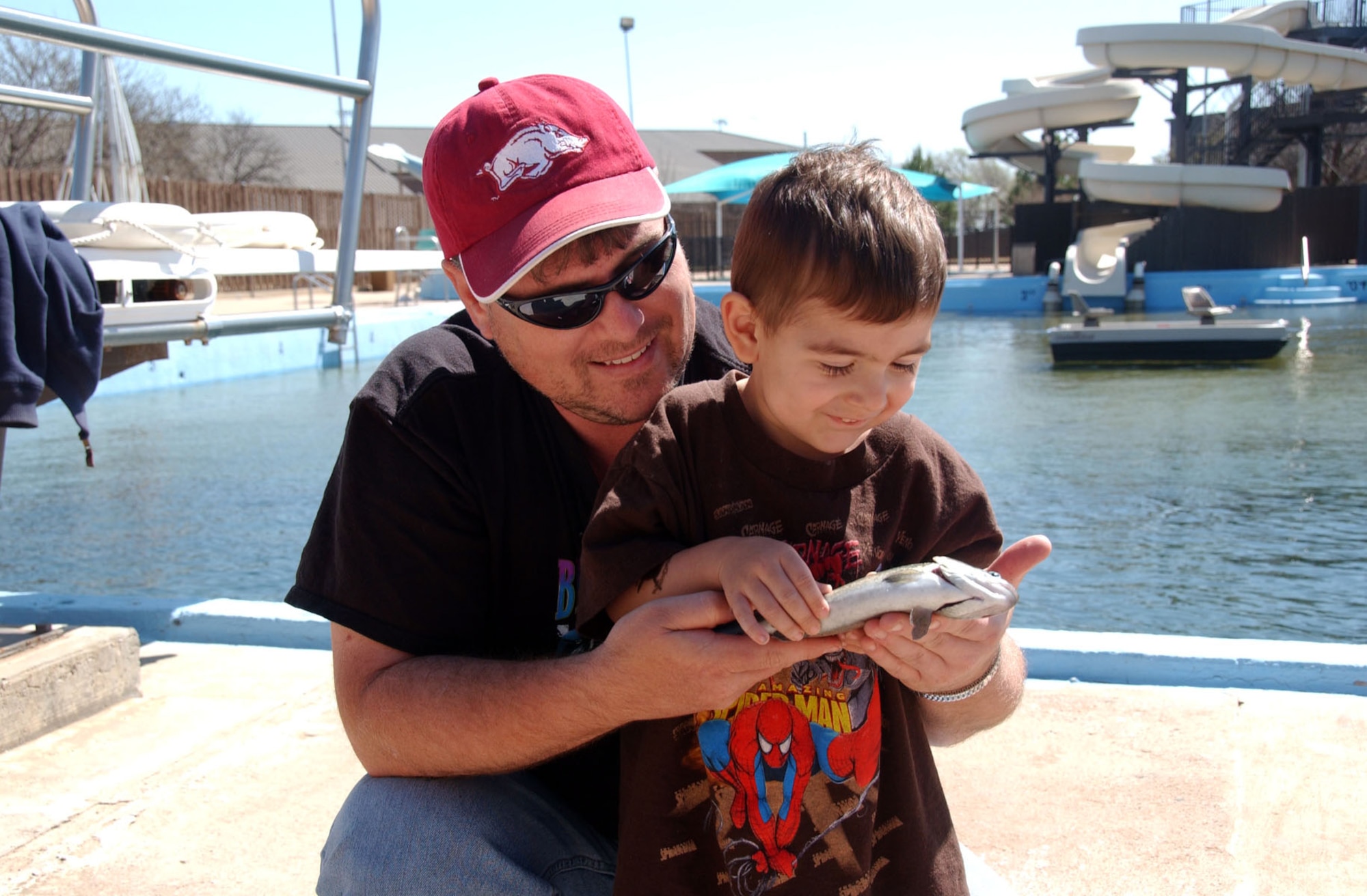 ALTUS AIR FORCE BASE, Okla. -- John Ault hands his son, Connor, 3, the fish he caught during the opening day of the 14th Annual Outdoor Recreation Trout Derby at the Base Pool March 20. More than 650 pounds of Rainbow Trout was dumped into the pool. (U.S. Air Force photo by Senior Airman Clinton Atkins)
