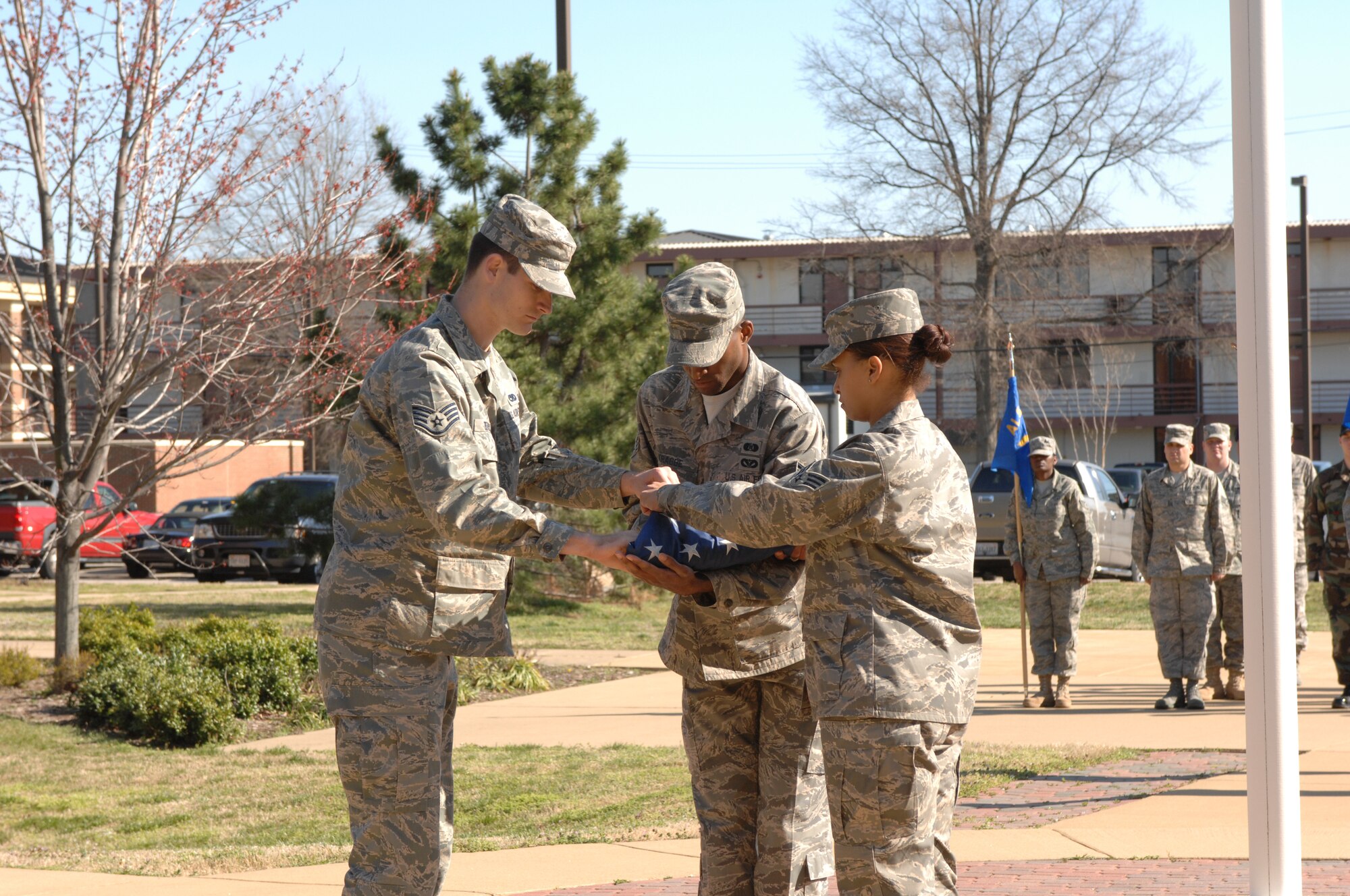 LANGLEY AIR FORCE BASE, Va. --Staff Sgt. William Beasley, 10th Intelligence Squadron, Senior Airman Tatchy Kragbe from the 1st Civil Engineer Squadron and Senior Airman Jamie Dixon finish folding the American flag during a Formal Retreat Ceremony preformed by  Airmen Leadership School Class 08-C March 20. (U.S.  Air Force photo/Tech. Sgt. Wickes)