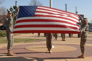 LANGLEY AIR FORCE BASE, Va. -- Staff Sgt. William Beasley, 10th Intelligence Squadron and Senior Airman Jamie Dixon, 1st Fighter Wing, show the American flag before folding it  during a formal retreat ceremony preformed by Langley's Airman Leadership School Class 08-C March 20. (U.S.  Air Force photo/Tech. Sgt. April Wickes)