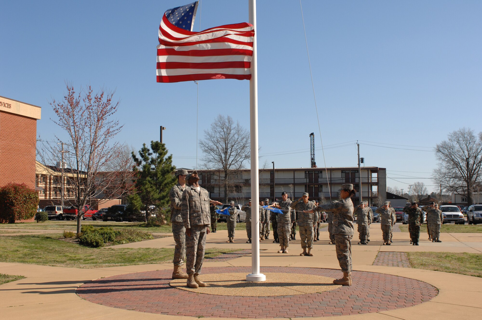 LANGLEY AIR FORCE BASE, Va.--Senior Airman Tatchy Kragbe from the 1st Civil Engineer Squadron  prepares to catch the American flag while Staff Sgt. William Beasley,  10th Intelligence Squadron and Senior Airman Jamie Dixon, 1st Fighter Wing lower it during a Formal Retreat Ceremony preformed by Airmen Leadership School Class 08-C March 20. (U.S.  Air Force photo/Tech. Sgt. Wickes)