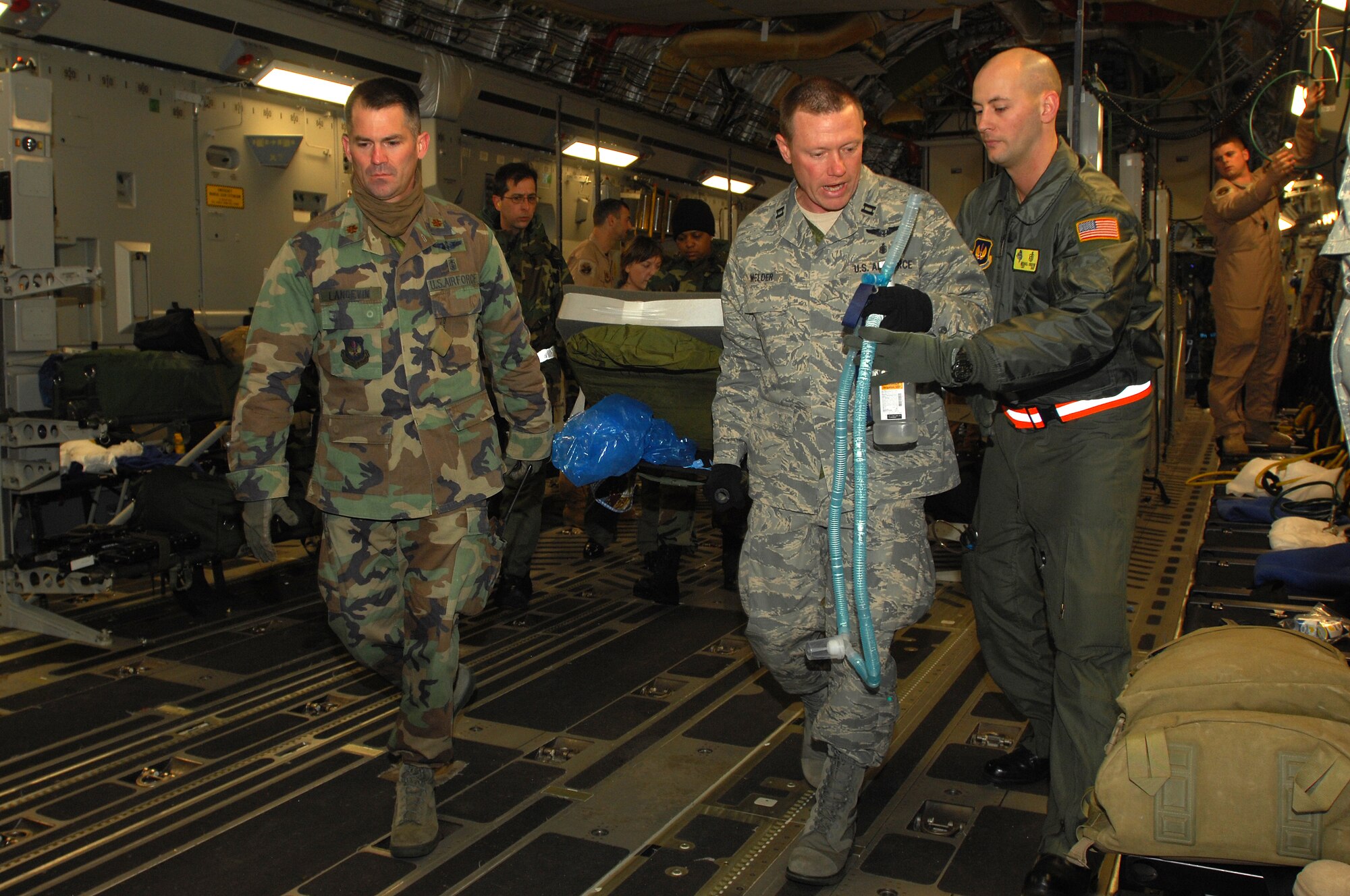 Members of Ramstein's 435th Contingency Aeromedical Staging Facility off load a three-year-old Iraqi burn victim. The Iraqi child and his mother will continue on to the states where he will receive further treatment. Photo by Airman 1st Class Kenny Holston*
