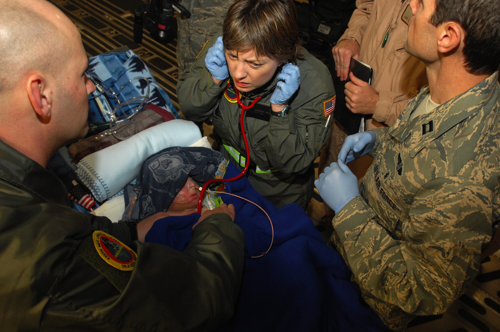 Navy Lieutenant Commander Micelle Perello checks the vital signs of a three-year-old Iraqi burn victim after arriving at Ramstein from Balad Air Base, Iraq on an Aero Medical Evacuation flight. The Iraqi child and his mother will continue on to the states where he will receive further treatment. Photo by Airman 1st Class Kenny Holston*