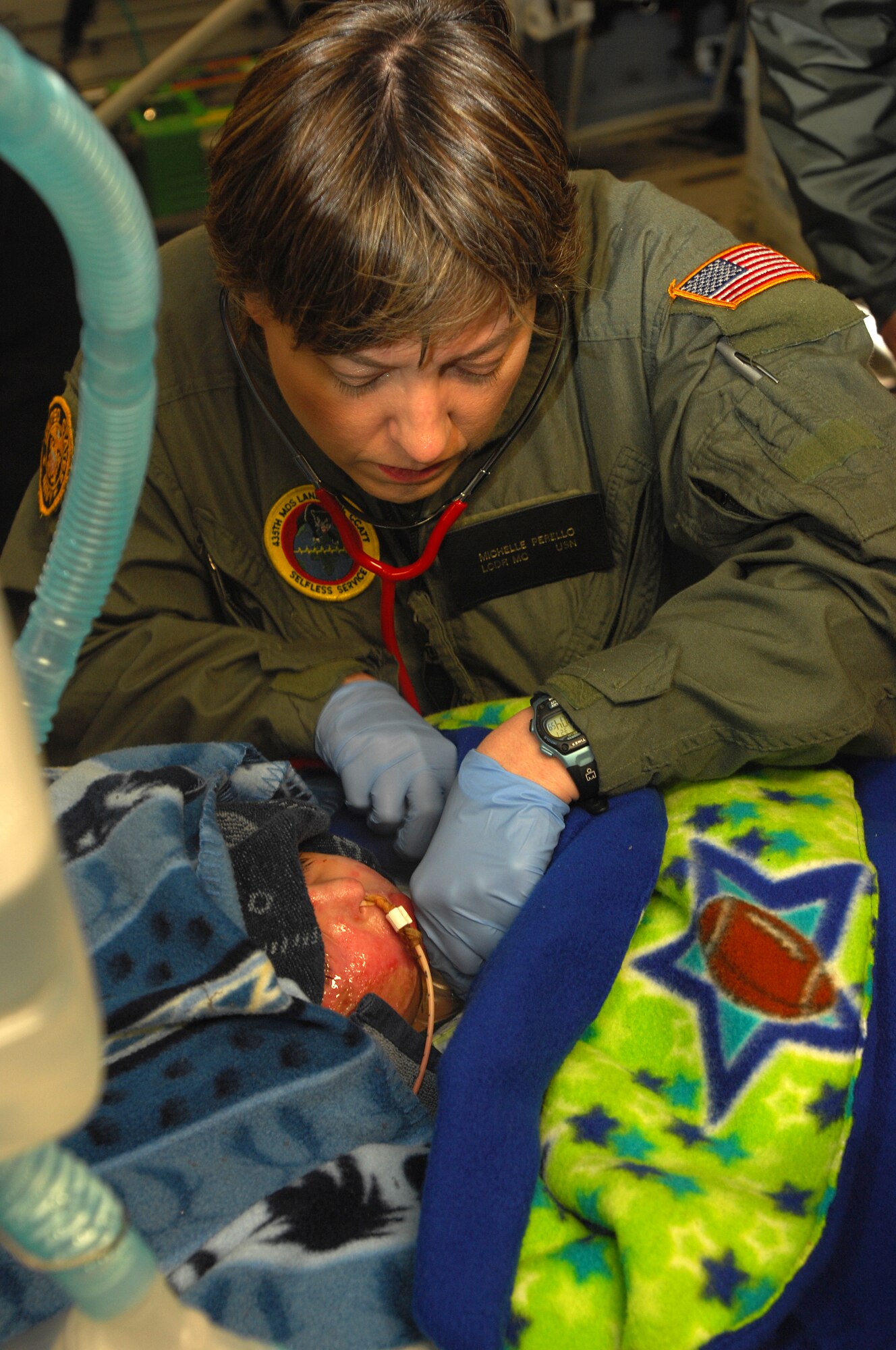 Navy Lieutenant Commander Micelle Perello checks the vital signs of a three-year-old Iraqi burn victim after arriving at Ramstein from Balad Air Base, Iraq on an Aero Medical Evacuation flight. The Iraqi child and his mother will continue on to the states where he will receive further treatment. Photo by Airman 1st Class Kenny Holston*