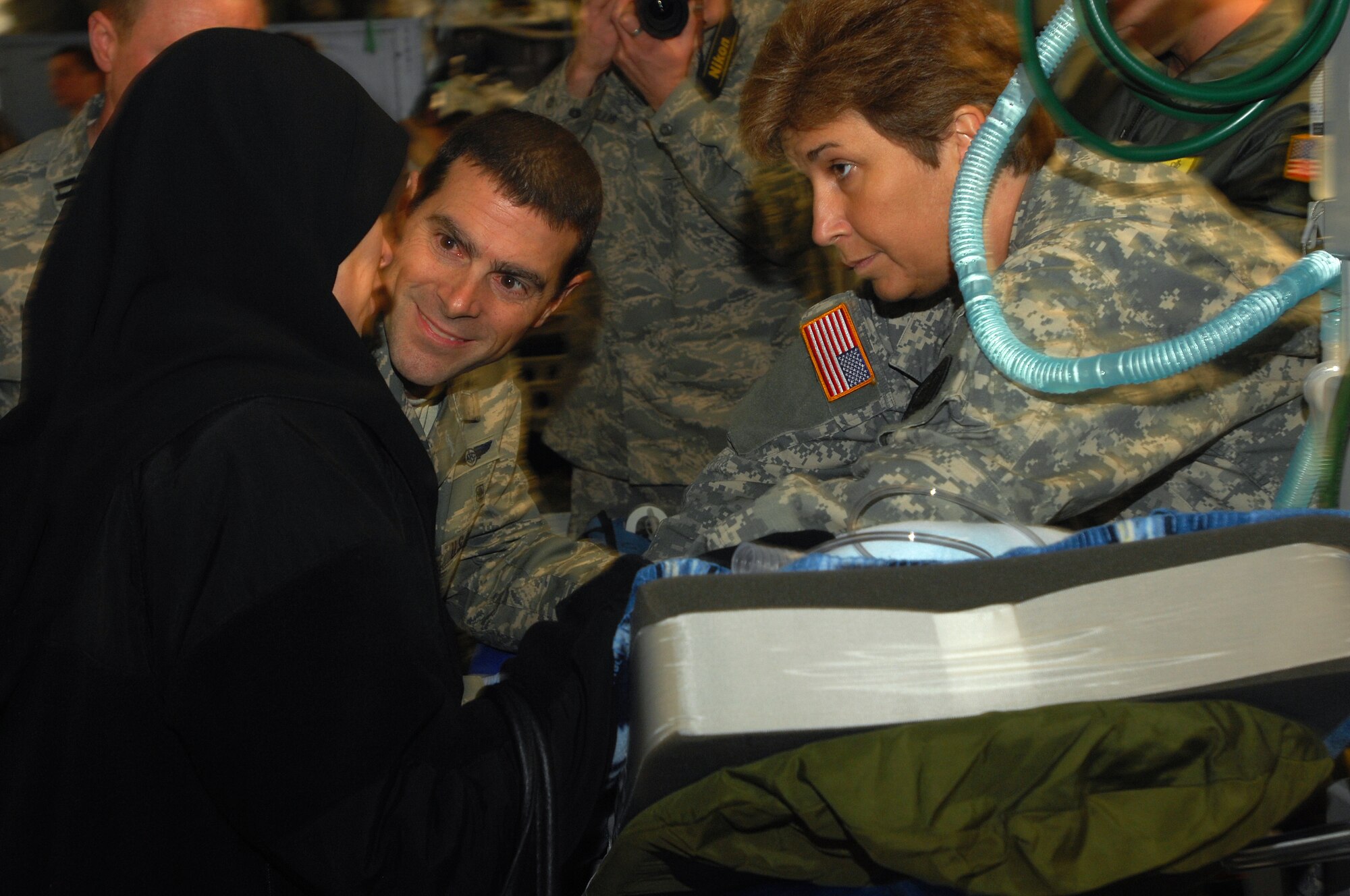Capt. Michael Riegler, ensures an Iraqi mother that her three-year-old son, a burn victim, is going to be fine after landing at Ramstein on an Aero Medical Evacuation flight. The Iraqi child and his mother will continue on to the states where he will receive further treatment. Photo by Airman 1st Class Kenny Holston*