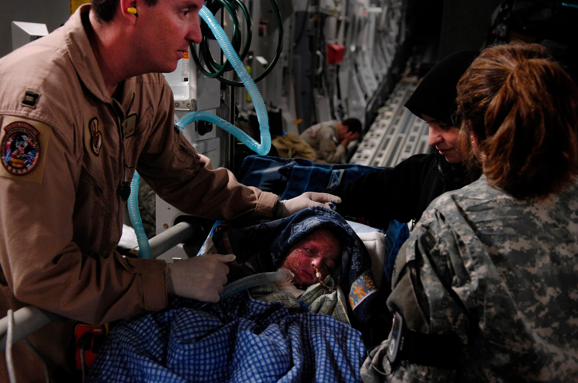 BALAD AIR BASE, Iraq -- Capt. Jay Williams, 332nd Expeditionary Aeromedical  Evacuation Flight Critical Care Transportation Team, talks with Amil, the mother of 3-year-old Iraqi burn victim Al Amreeki, before a flight to the United States March 21.  Al Amreeki was only given 48 hours to live after being burned in a fire. Two months later he and his mother are being transported back to the United States for further treatment and physical therapy. U.S. Air Force Photo/Tech. Sgt. Jeffrey Allen 
