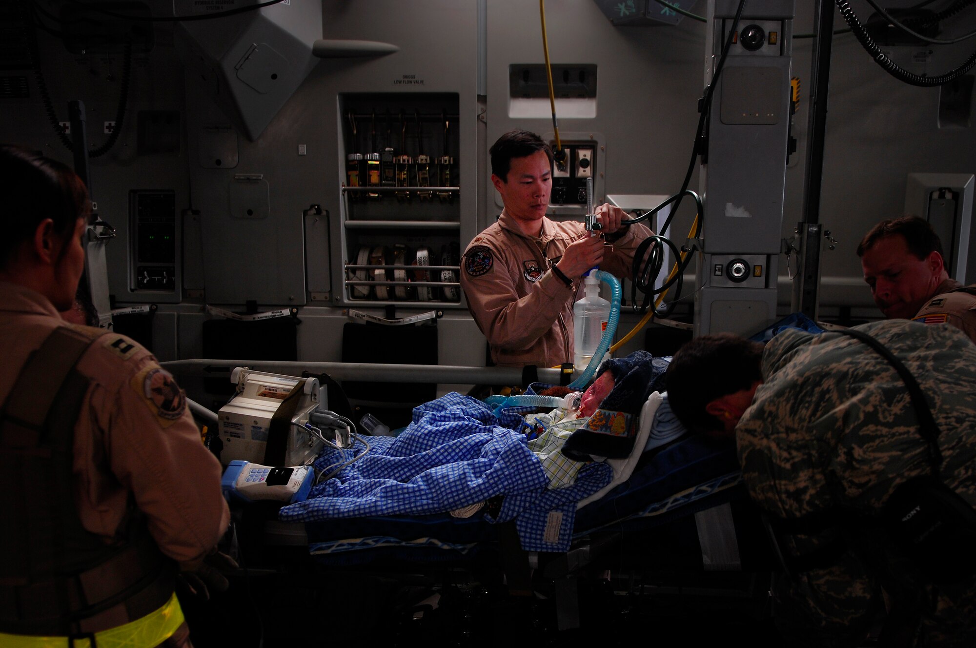 BALAD AIR BASE, Iraq -- Maj. Patrick Hsieh, 332nd Expeditionary Aeromedical  Evacuation Flight Critical Care Transportation Team, prepares 3-year-old Iraqi burn victim Al Amreeki, for a flight to the United States on March 21.  Al Amreeki was only given 48 hours to live after being burned in a fire.  Two months later he and his mother are being transported back to the United States for further treatment and physical therapy. U.S. Air Force Photo/Tech. Sgt. Jeffrey Allen 