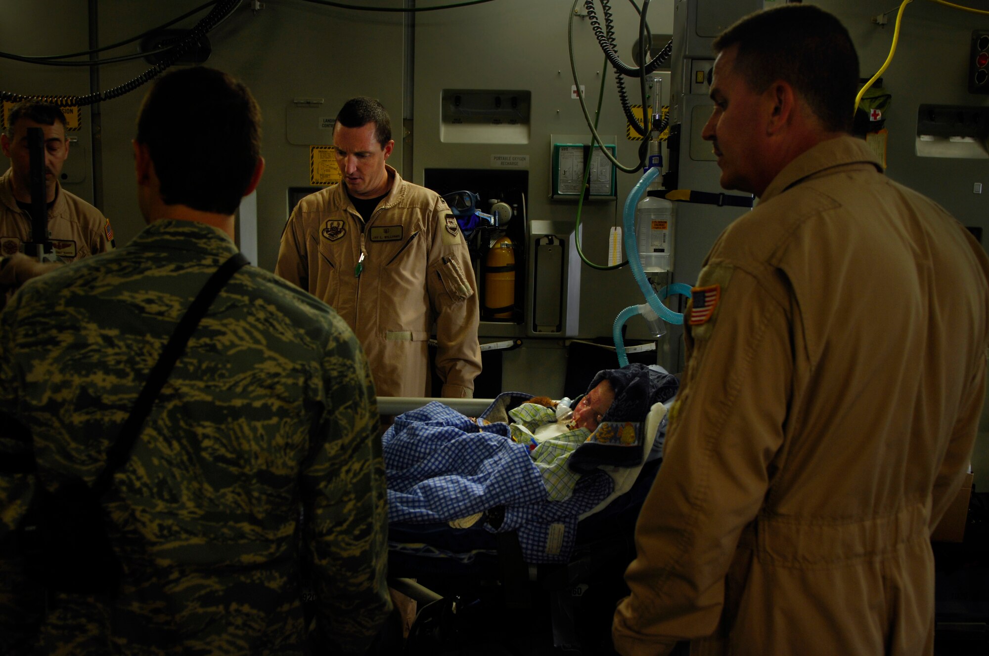 BALAD AIR BASE, Iraq -- Capt. Jay Williams, 332nd Expeditionary Aeromedical  Evacuation Flight Critical Care Transportation Team, prepares 3-year-old burn victim Al Amreeki, for a flight to the United States March 21.  Al Amreeki was only given 48 hours to live after being burned in a fire.  Two months later he and his mother are being transported back to the United States for further treatment and physical therapy. U.S. Air Force Photo/Tech. Sgt. Jeffrey Allen 