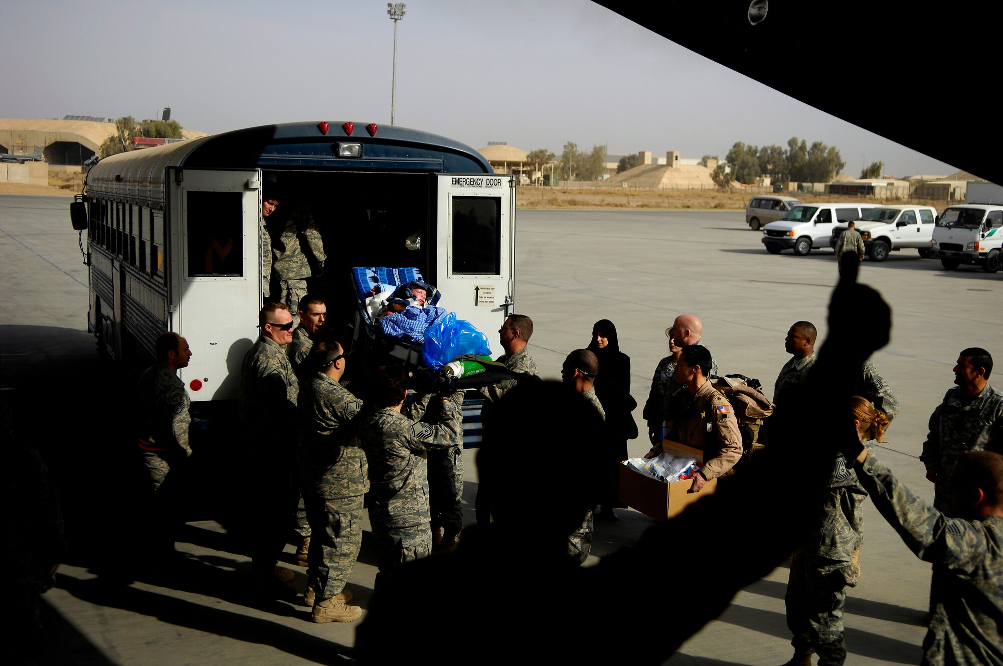 BALAD AIR BASE, Iraq -- Al Amreeki, a 3-year-old Iraqi burn victim is carried from a  bus to a C-17 Globemaster III that will fly him to the United States. Al Amreeki was only given 48 hours to live after being burned in a fire.  Two months later he and his mother are being transported back to the United States for further treatment and physical therapy. (U.S. Air Force Photo/Tech. Sgt. Jeffrey Allen)