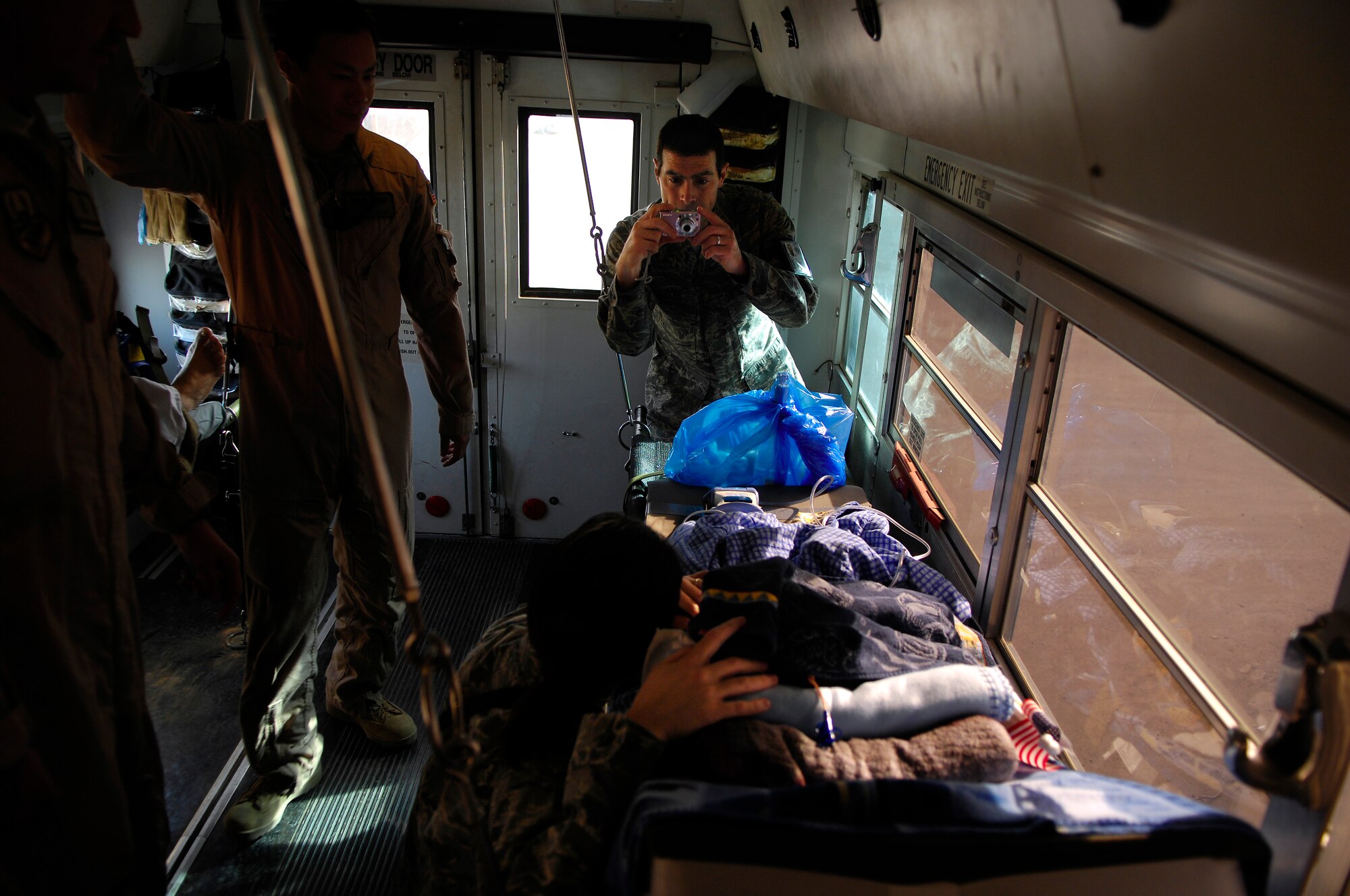 BALAD AIR BASE, Iraq -- Capt. Michael Riegler, 332nd Expeditionary Medical Operations Squadron nurse, takes a photo of Al Amreeki, a 3-year-old Iraqi burn victim on the bus transporting him to an awaiting C-17 Globemaster III March 21. Al Amreeki was only given 48 hours to live after being burned in a fire.  Two months later he and his mother are being transported back to the United States for further treatment and physical therapy. U.S. Air Force Photo/Tech. Sgt. Jeffrey Allen 