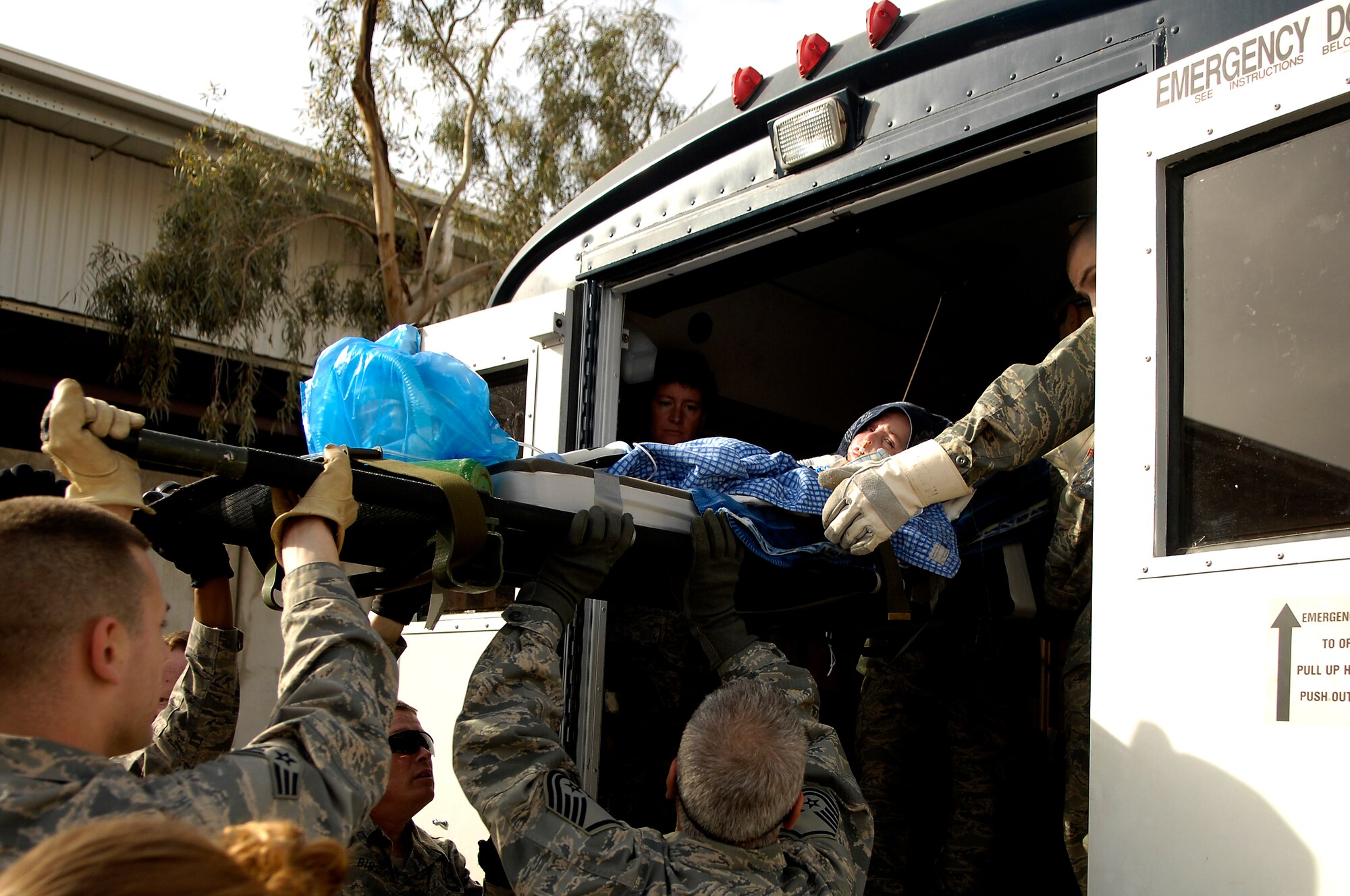 BALAD AIR BASE, Iraq -- Al Amreeki, a 3-year-old Iraqi burn victim, is carried onto a bus outside the Air Force Theater Hospital March 21. The bus will take him to a C-17 Globemaster III that will fly him to the United States. Al Amreeki was only given 48 hours to live after being burned in a fire.  Two months later he and his mother are being transported back to the United States for further treatment and physical therapy. (U.S. Air Force Photo/Tech. Sgt. Jeffrey Allen)