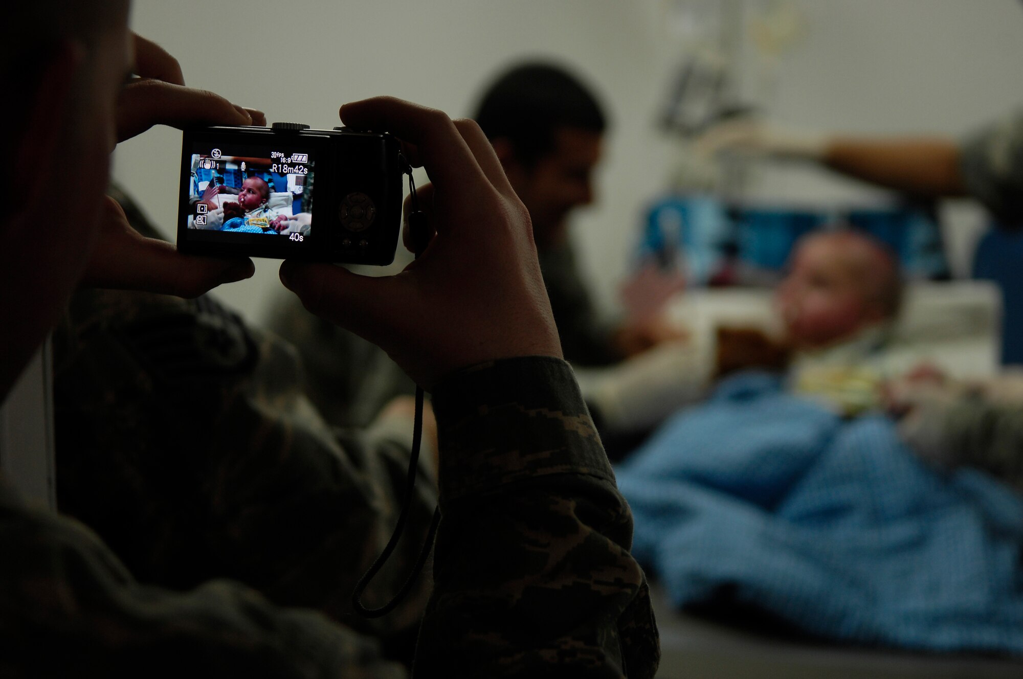 BALAD AIR BASE, Iraq -- A member of the 332nd Expeditionary Medical Operations Squadron takes a picture March 21 of Al Amreeki, a 3-year-old Iraqi burn victim who was cared for by the staff at the Air Force Theater Hospital here. U.S. Air Force Photo/Tech. Sgt. Jeffrey Allen