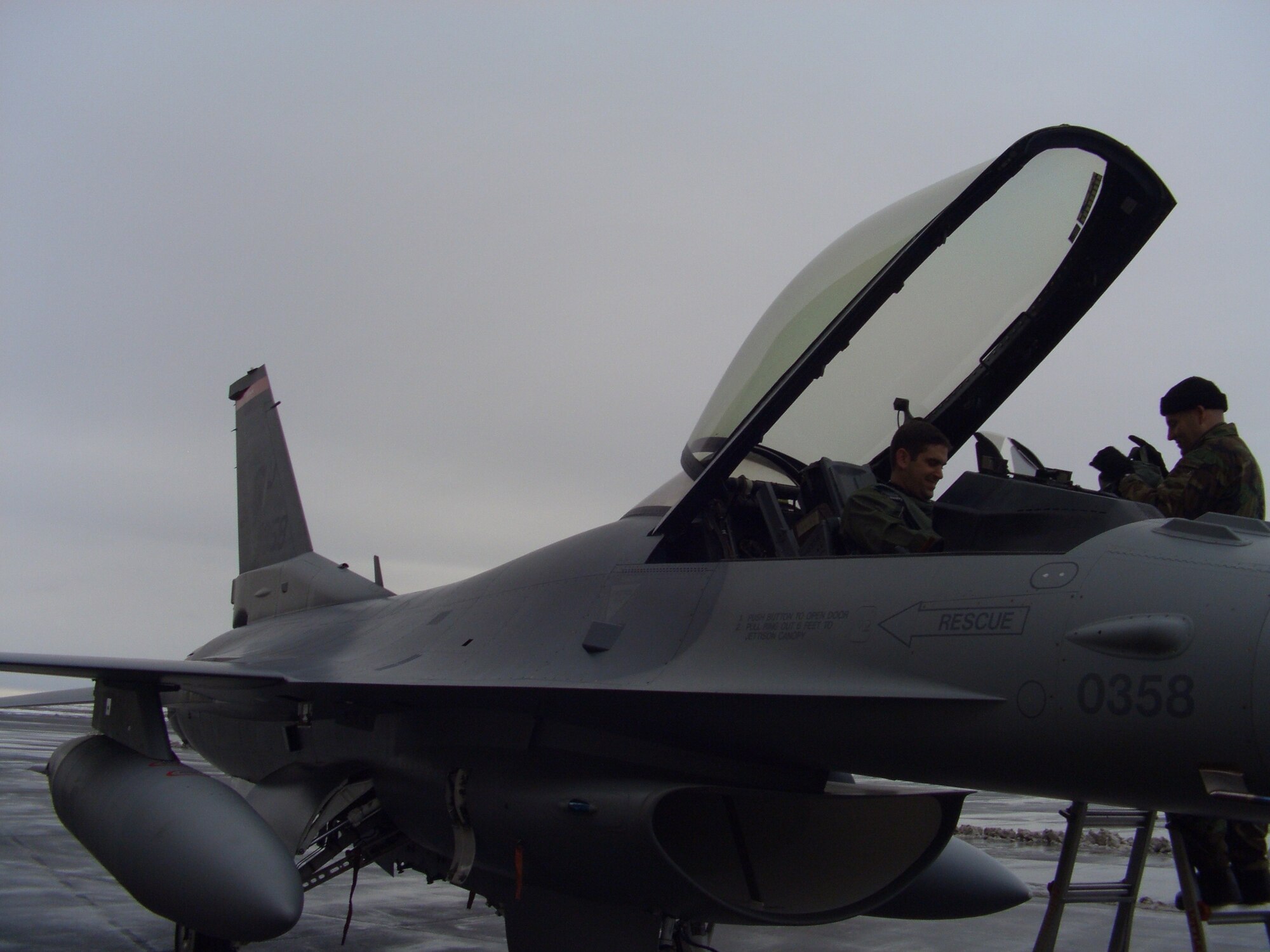 KEFLAVIK, Iceland – Master Sgt. Wes Ruuti, 52nd Aircraft Maintenance Squadron, assists 1st Lt. Scott Butler, 22nd Fighter Squadron, after an operational check flight March 12, 2008. The Spangdahlem Airmen were in Keflavik, Iceland, to fix and fly back two diverted F-16s. (U.S. Air Force photo/Lt. Col. Tony Forkner)