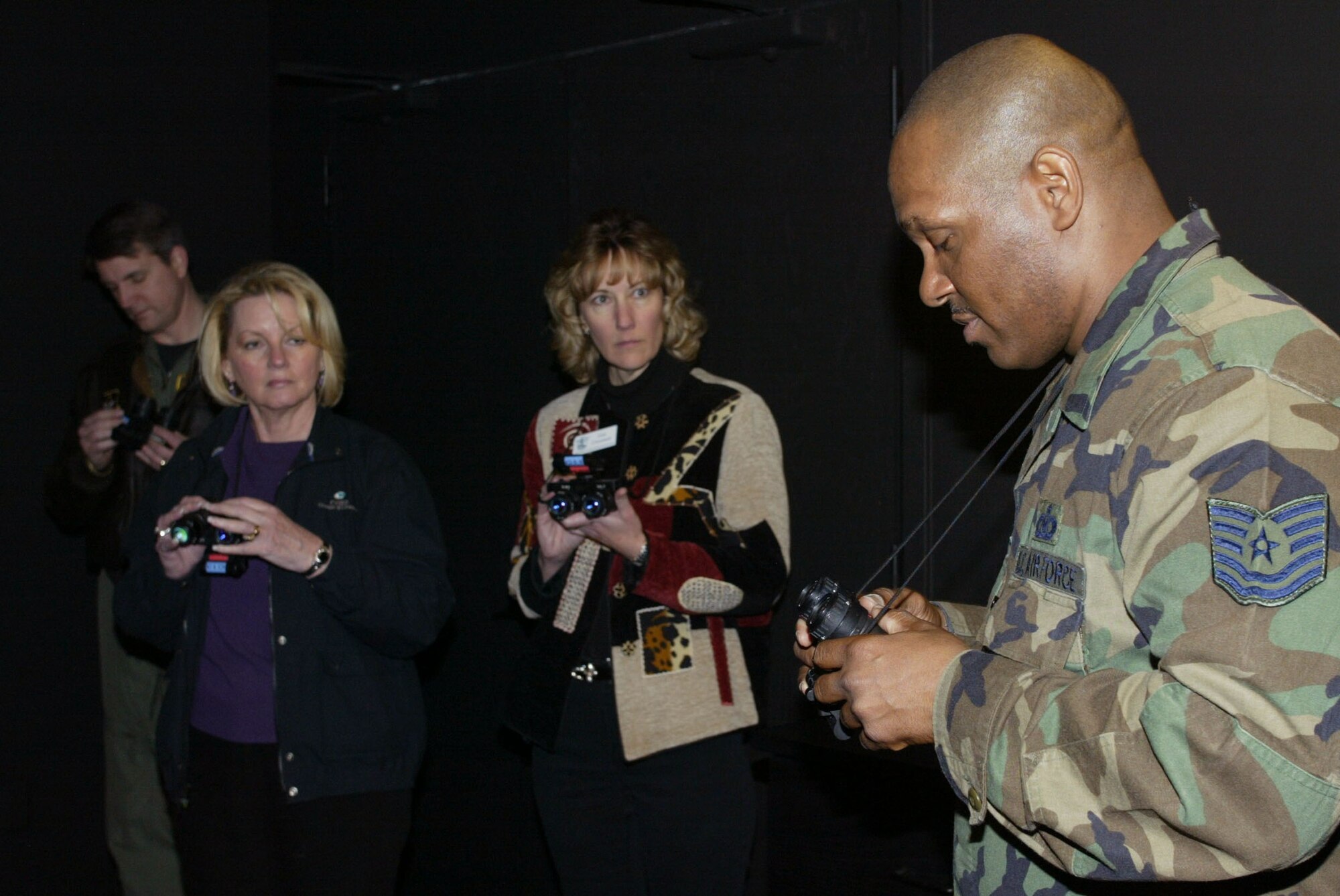 Suzanne Appenzeller and Lisa Crossman, of the Honorary Commanders Association, look on as Tech. Sgt. Mickey Smith from the 94th Operation Support Squadron Life Support shop, explains night vision goggles. The demonstration covered the different ways pilots use night vision, how they recognize terrain features and infrared signals. The Honorary Commanders Association visited base March 20 for at tour of the Air Force Reserve mission of the 94th Airlift Wing. This is one of several tours and trips the group will experience throughout the year as they learn more about the people and mission of the Air Force Reserve and sister services.