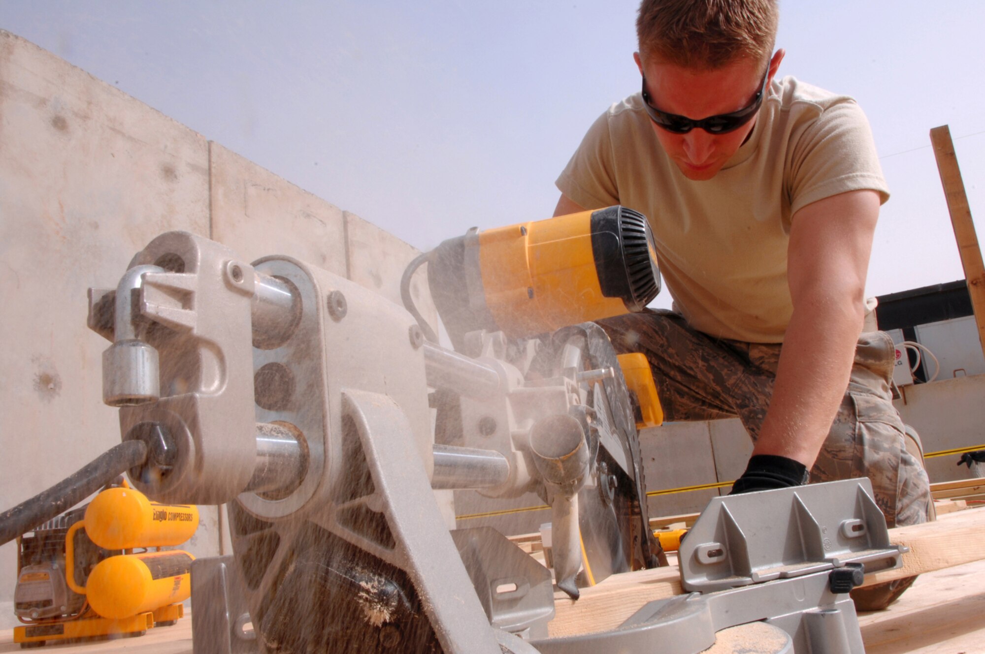 BALAD AIR BASE, Iraq -- Senior Airman James Robison, 332nd Expeditionary Civil Engineer Squadron structural engineer, cuts wood for a new pavilion in the Housing 6 area here, March 19. The pavilion will offer a shady place for servicemembers to hang out during the hot summer months. Airman Robison is deployed from Malmstrom Air Force Base, Mont. (U.S. Air Force photo/ Senior Airman Julianne Showalter)