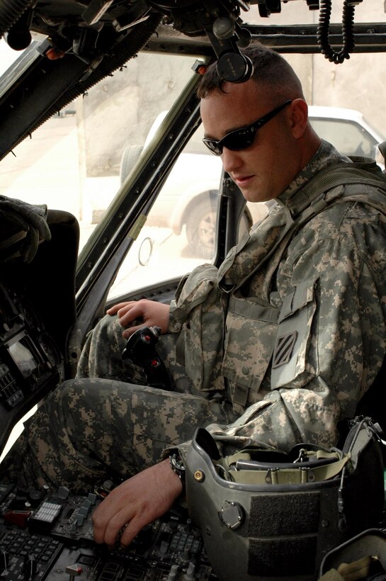 Army Chief Warrant Officer Fred White, a Black Hawk pilot with 2nd Battalion, 3rd Aviation Regiment, 3rd Combat Aviation Brigade, 3rd Infantry Division, demonstrates the preparations he makes before a flight March 18, 2008, at the 3rd CAB flight line in Baghdad. White lost two fingers in a 2003 roadside bomb blast and overcame his injuries to become a pilot. Photo by Spc. Emily J. Wilsoncroft, USA