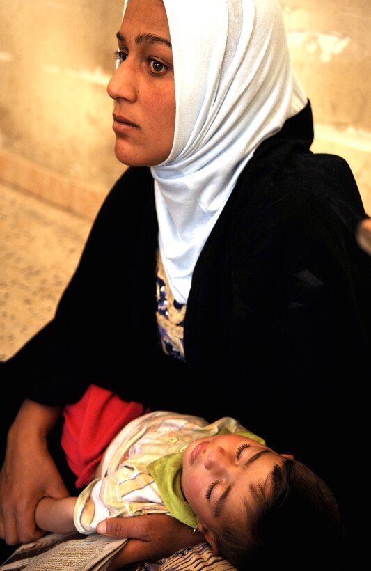 An Iraqi mother holds her son as she waits to see doctors during a combined medical effort in Bata, Iraq, March 17, 2008. 