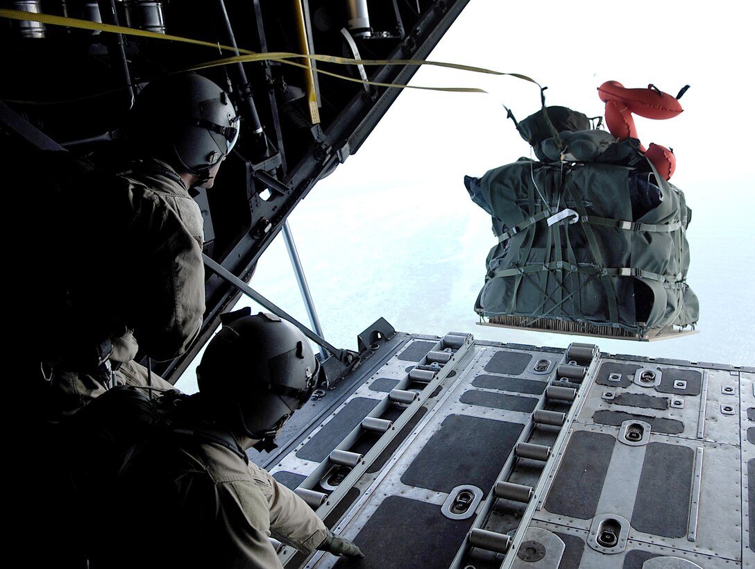 U.S. Air Force Senior Airmen Geoffery Koppel and Justin Gielski, loadmasters assigned to the 71st Search and Rescue Squadron out of Moody Air Force Base, Ga., push out a Zodiac boat bundle while in flight during a pararescue training jump aboard an HC-130 aircraft over Djibouti March 13, 2008.