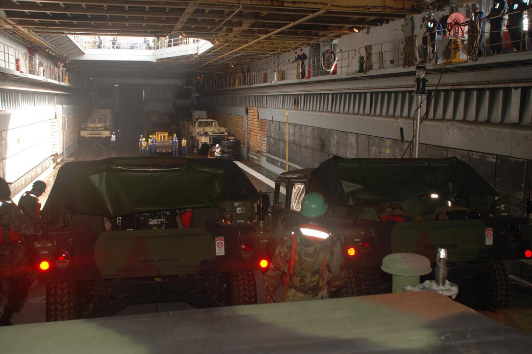 Marines from 4th Landing Support Battalion, 4th Marine Logistics Group, prepare to drive their humvees from the Improved Navy Lighterage System into the well-deck of the USS Fort McHenry (LSD 43). Aboard the ship, the Marines will prep the vehicles for a humanitarian assistance mission to Monrovia, Liberia as part of West African Training Cruise 2008