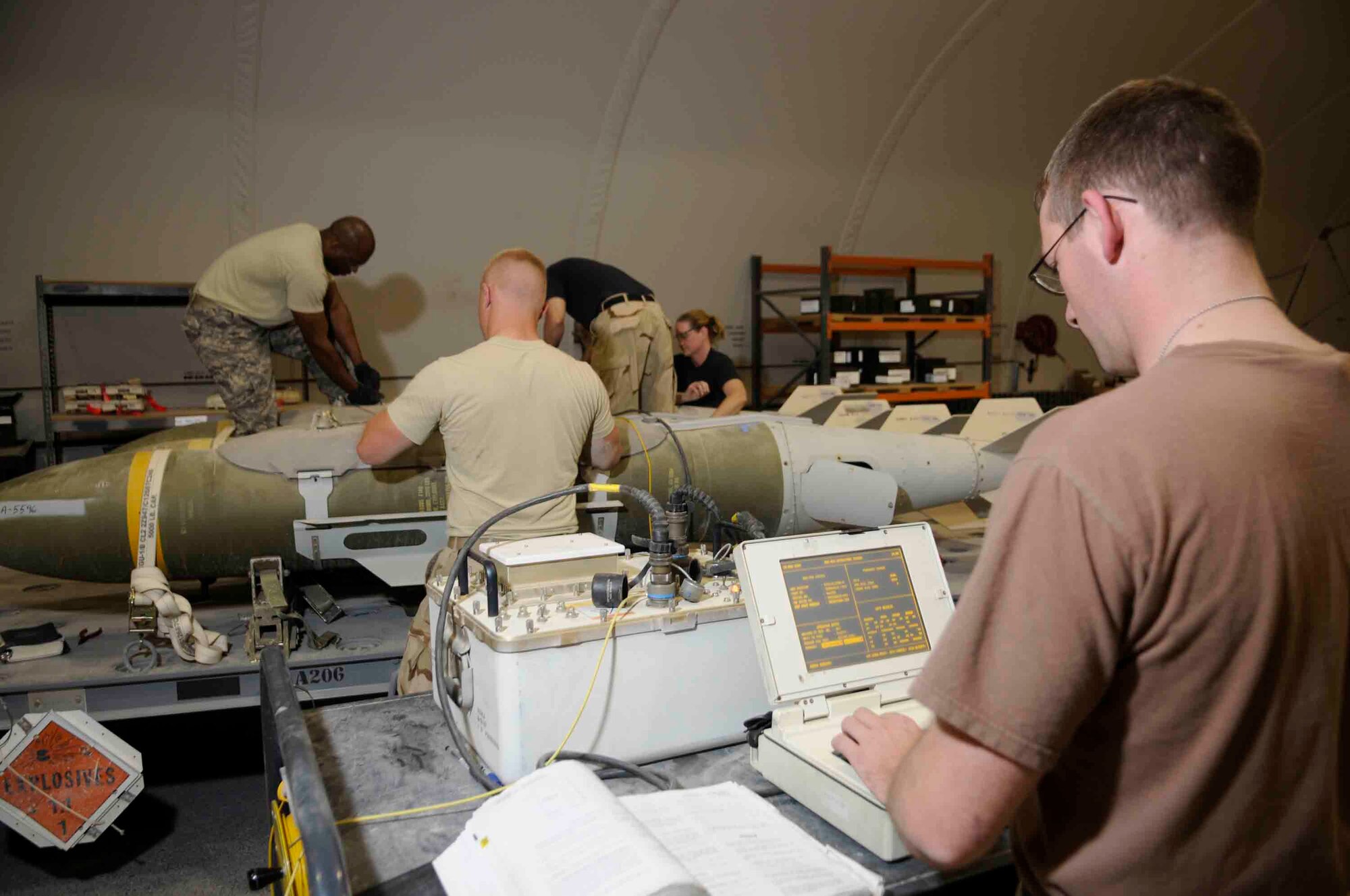 Airman Monteer uses common munitions bit reprogramming equipment to perform a function test on the tail assembly while maintenance crew perform post-assembly functional test on GBU-31 at a Southwest Asia air base March 18. (U.S. Air Force photo/Tech. Sgt. Johnny Saldivar)