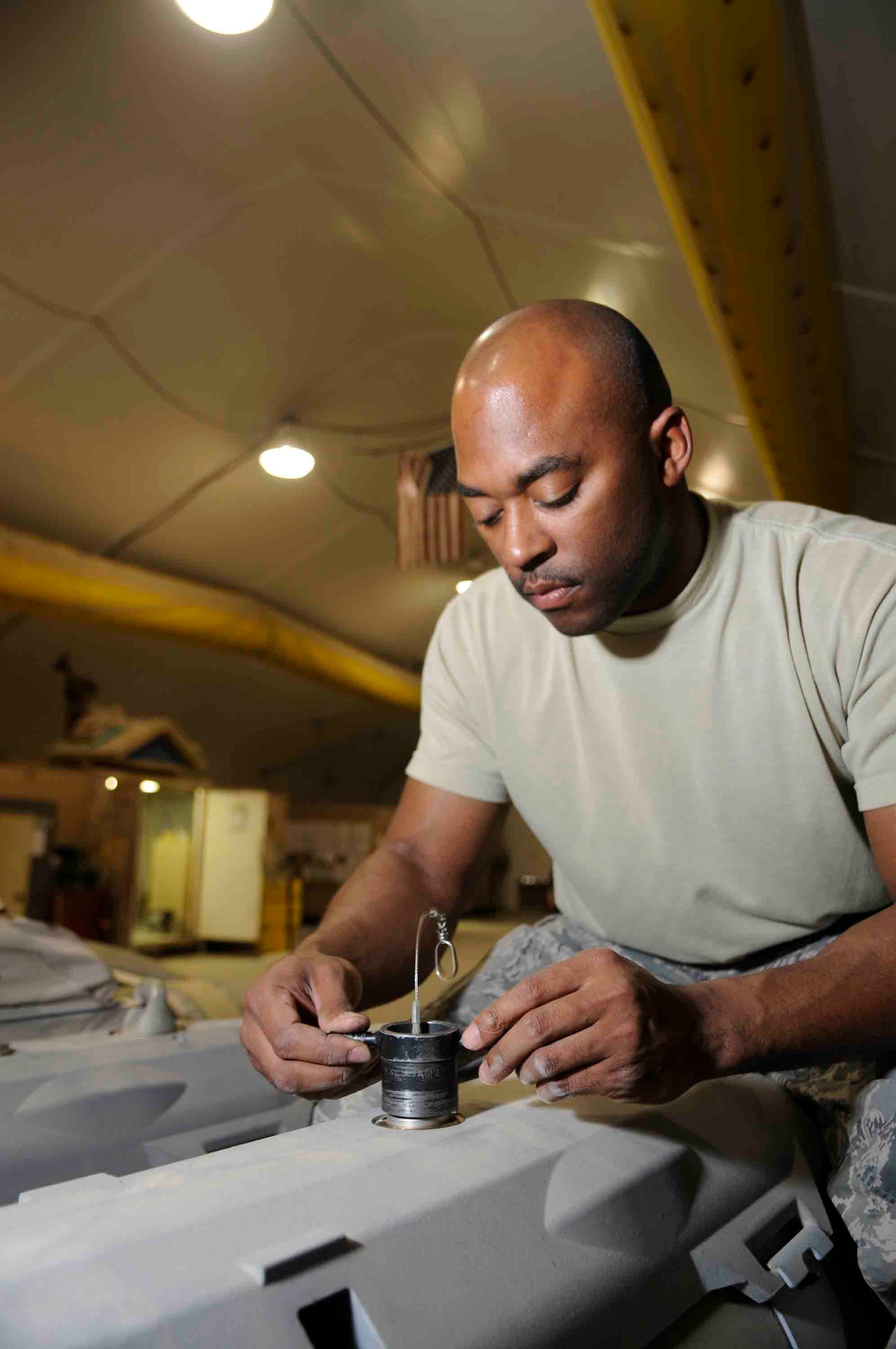 Staff Sgt. Brandon Valentine, 379th EMXS munitions specialist, secures a fuse initiator to a bomb at a Southwest Asia air base March 18. His efforts provides connectivity between the fuse and initiator.  (U.S. Air Force photo/Tech. Sgt. Johnny Saldivar)
