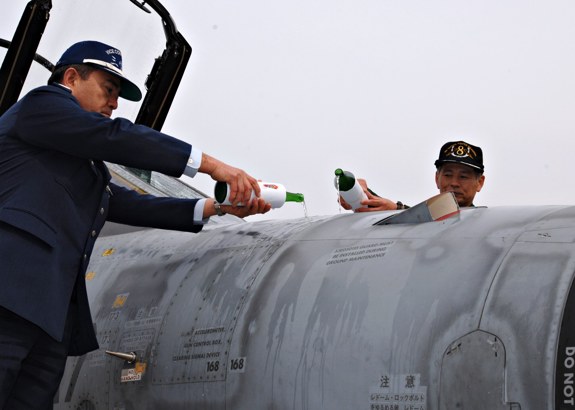 MISAWA AIR BASE, Japan -- Japan Air Self Defense Force, 3rd Air
Wing vice commander Col. Hisanori Toufuku and 8th Fighter Squadron
Commander Lt. Col. Yoshihide Nunomura pour ceremonial sake over a
decommissioned F-4 on March 19, 2008. This symbolic gesture is a way of
rewarding the aircraft for its years of faithful service. (U.S. Air Force photo by Airman 1st Class Christopher Bevins)