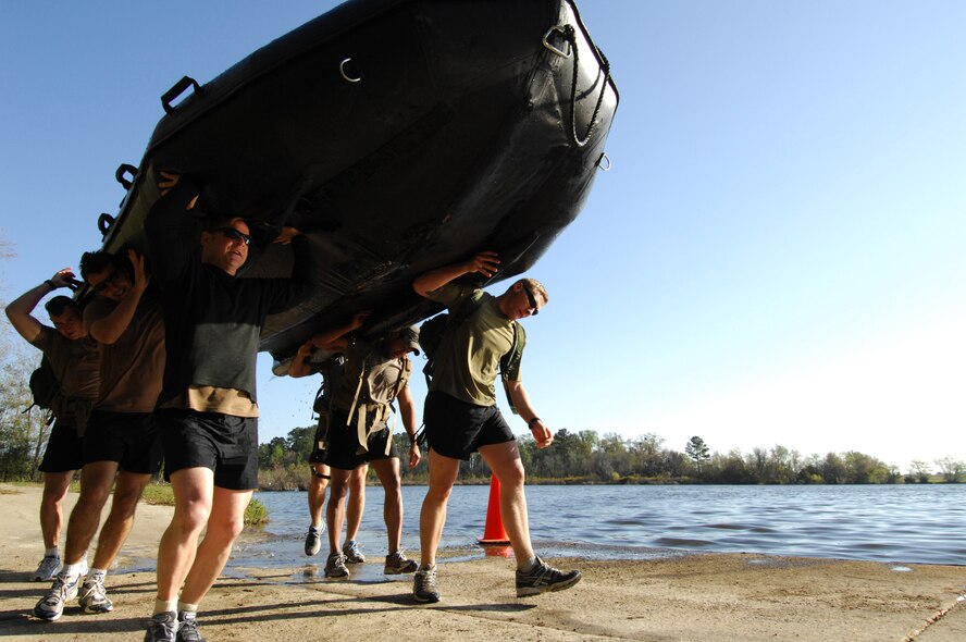 MOODY AIR FORCE BASE, Ga. -- Members of the 38th Rescue Squadron carry a Zodiak inflatable boat after paddling it across Mission Lake during the Inaugural Maltz/Plite Monster Mash. The Monster Mash is an annual competition between pararescuemen here that pushes their skills and endurance to the limits. It also pays tribute to two members of the team that were killed in action in Afghanistan March 23, 2003. (U.S. Air Force photo by Staff Sgt. Joshua T. Jasper) 