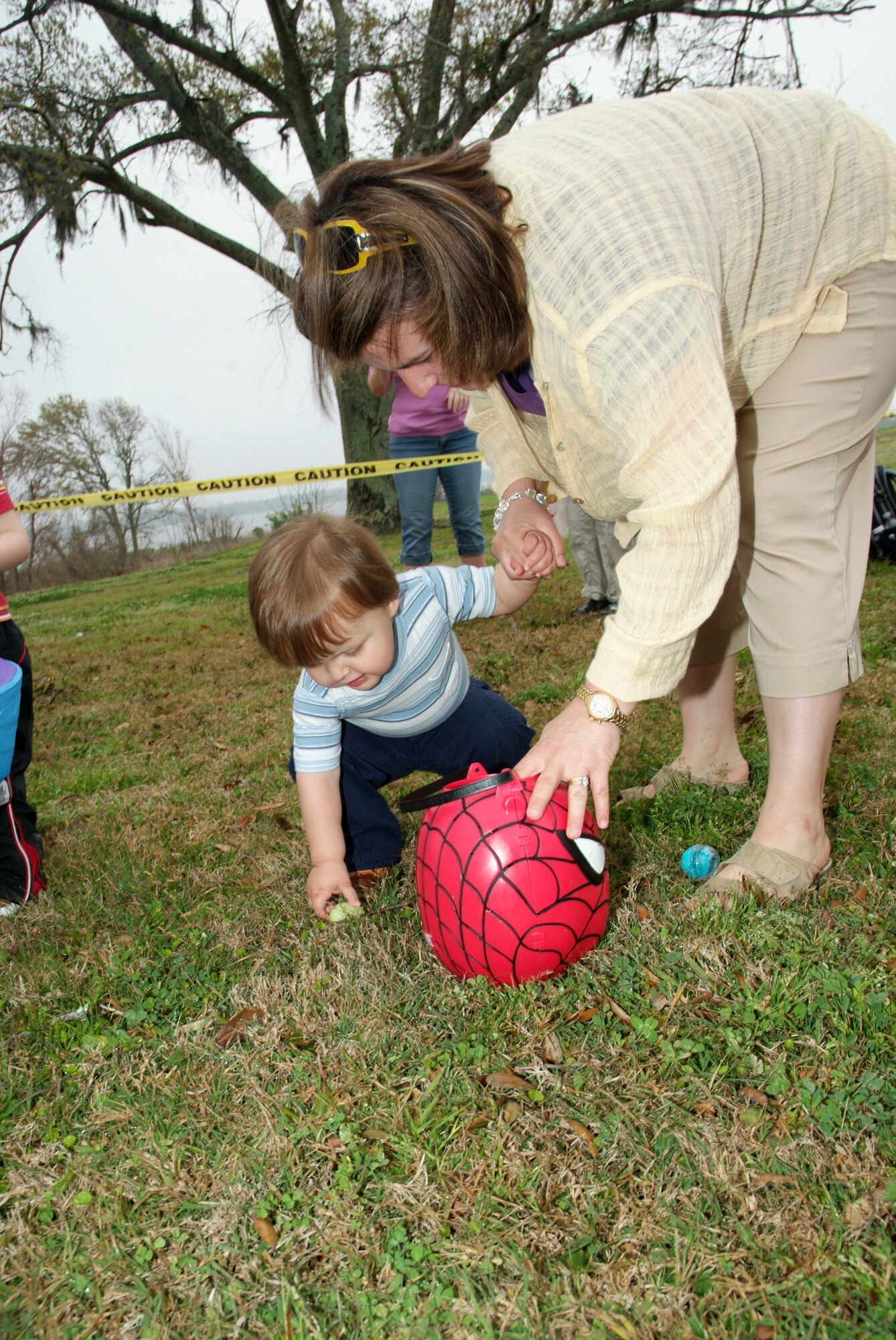 Eighteen-month-old Dylan Iverson collects eggs during Saturday’s Easter egg hunt in marina park with his mom, Capt. Lisa Iverson.  Captain Iverson is a reservist assigned to the 81st Medical Group.  Dylan’s dad is Staff Sgt. Eric Iverson, 85th Engineering Installation Squadron.  (U.S. Air Force photo by Adam Bond)