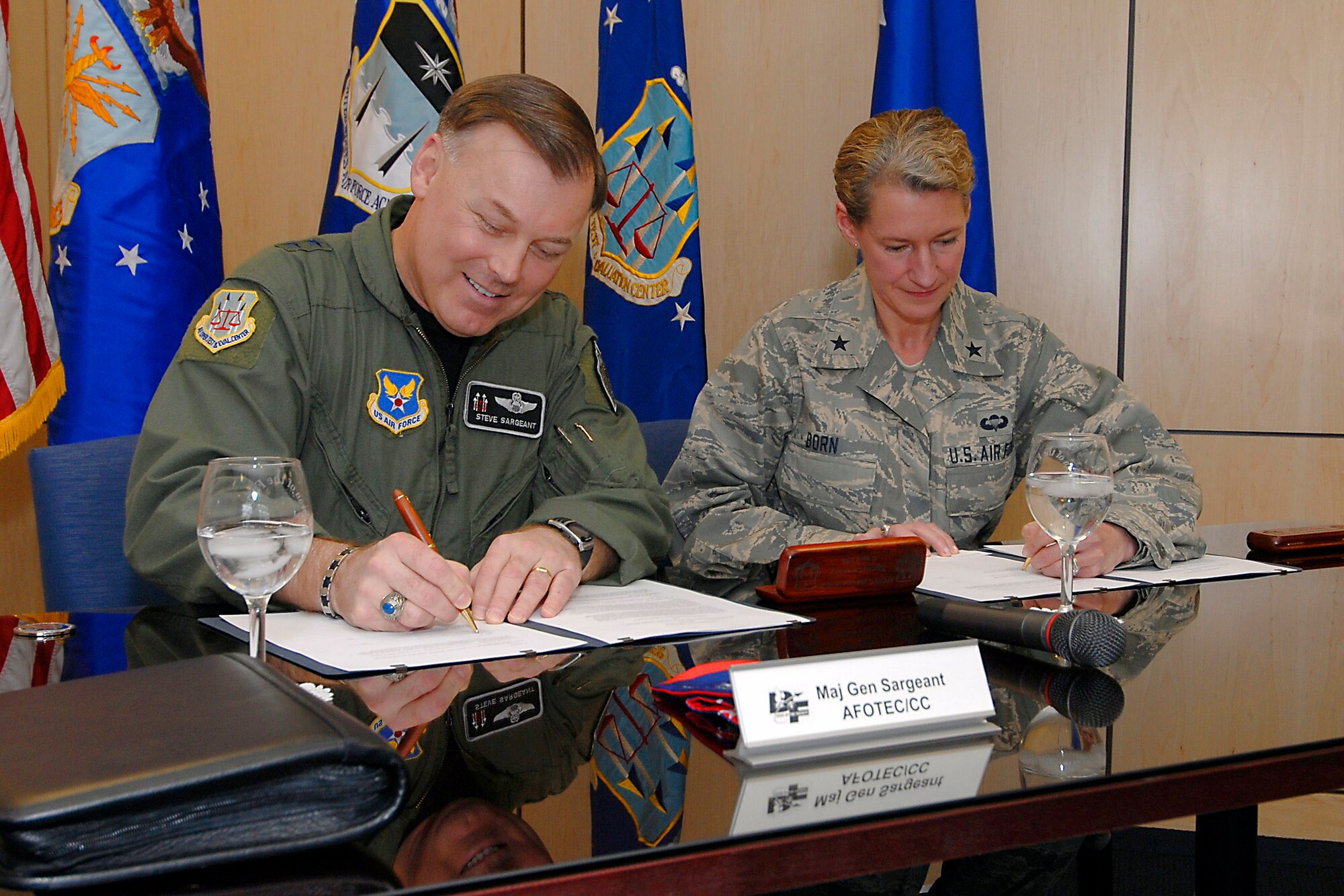 Maj. Gen. Stephen T. Sargeant (from left) and Brig. Gen. Dana H. Born sign a memorandum of agreement creating a mentoring program between the Air Force Operational Test and Evaluation Center and the U.S. Air Force Academy during a formal signing ceremony March 17 at the Academy in Colorado Springs, Colo. General Sargeant is the Air Force Operational Test and Evaluation Center commander from Kirtland Air Force Base, N.M., and General Born is the U.S. Air Force Academy dean of faculty. (U.S. Air Force photo) 
