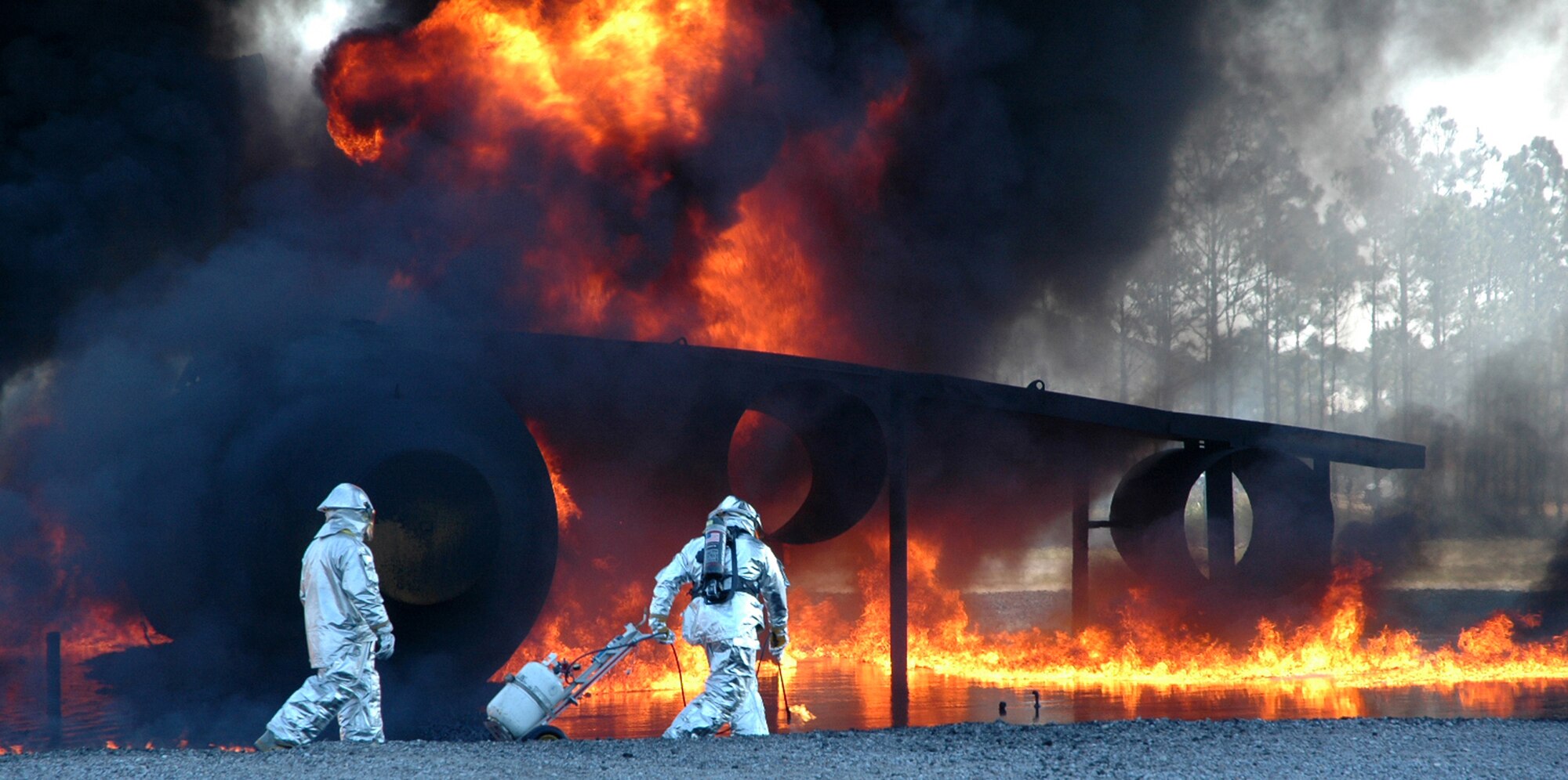 Two firefighters from Detachment 1 of the Rapid Engineer Deployable Heavy Operational Repair Squadron Engineers prepare a C-130 mockup to demonstrate their capabilities at the Silver Flag training area during an Reserve Officer Training Corps tour March 12.  (U.S. Air Force photo/Staff Sgt. Timothy R. Capling)