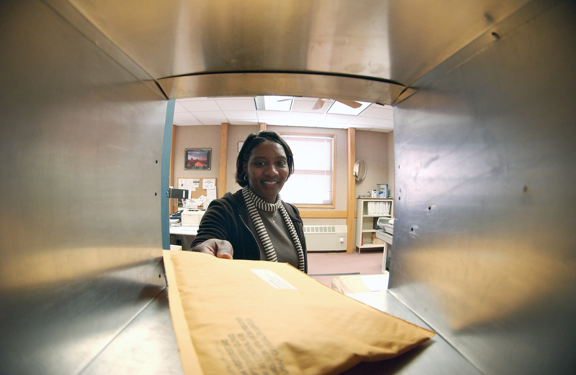 Pat Martin of the Official Mail Center places an official mail parcel into the proper mailbox March 21 at Eielson Air Force Base, Alaska. The mail workers provide services for receiving, processing distributing, and dispatching official and accountable mail, administrative communications, forms, publications, parcels and distribution for all base-supported activities. (U.S. Air Force Photo/Airman 1st Class Jonathan Snyder) (Released)