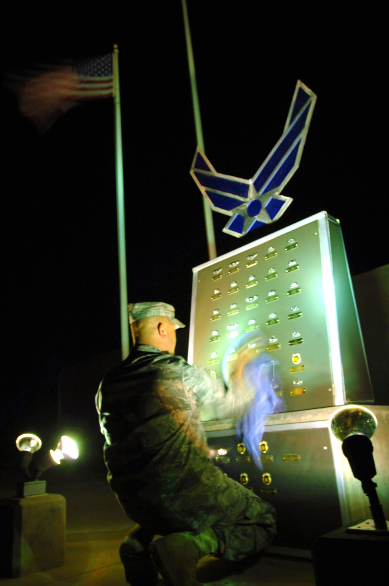 A technical sergeant deployed to the 407th Air Expeditionary Group cleans the Airmen's Memorial dedicated to those who have fallen in Operation Iraqi Freedom March 20 at Ali Base, Iraq. He cleans the memorial at least once a week and after every sand storm to make sure all the badges and nameplates shine. (U.S. Air Force photo/Staff Sgt. Nathan Gallahan)
