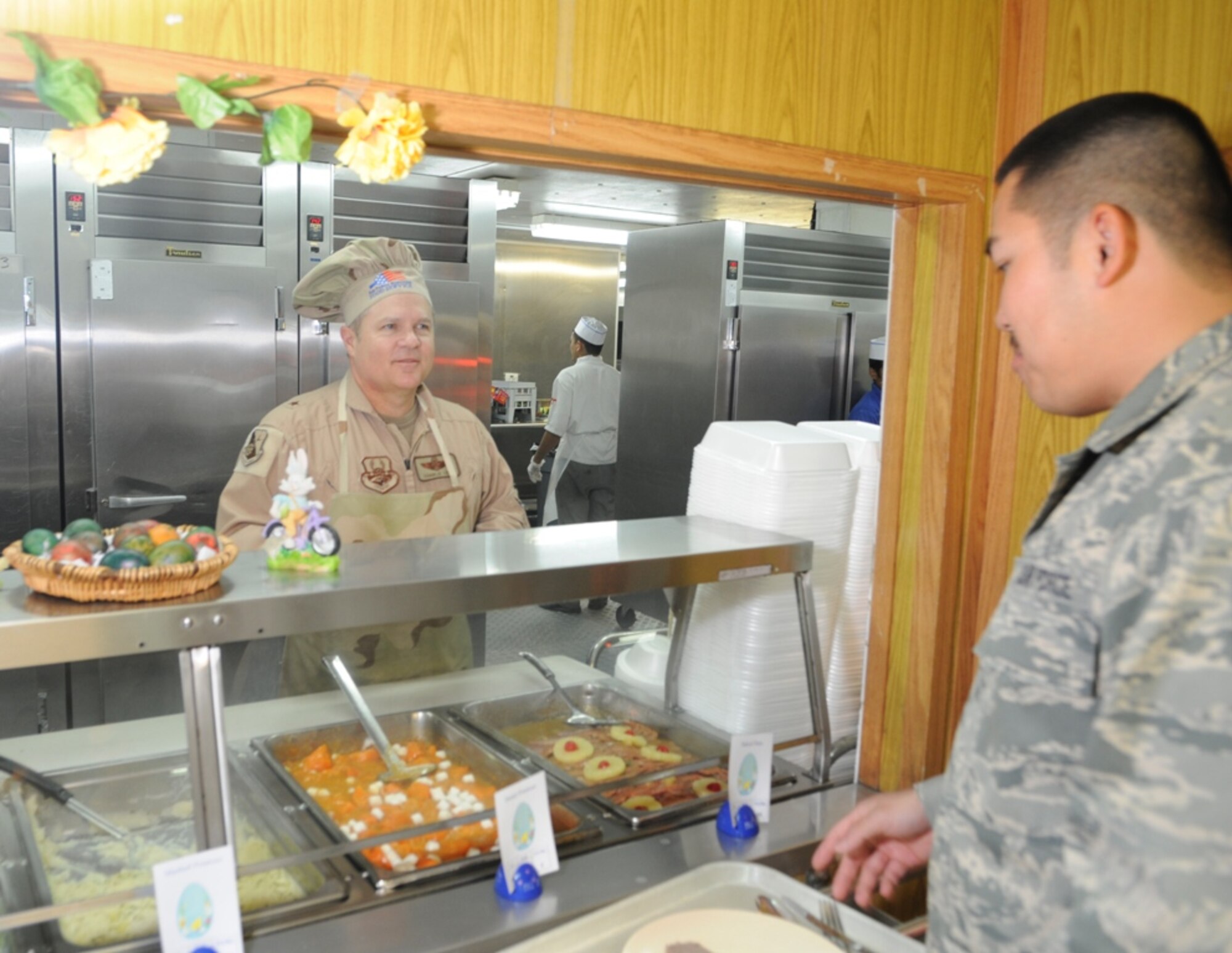 379th Air Expeditionary Wing commander Brig. Gen. Charlie Lyon serves Easter dinner at the Independence Dining Facility March 22.  Several commanders and senior non-commissioned officers from throughout the installation volunteered to serve Easter meals and greet Airmen.  (U.S. Air Force photo/Tech. Sgt. Johnny Saldivar)